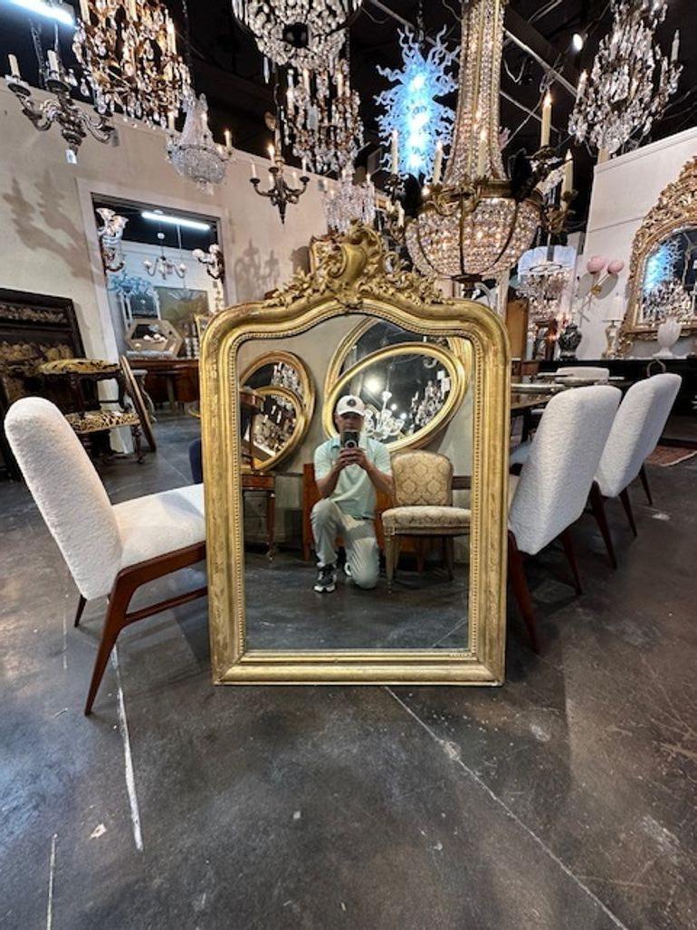 Very fine antique French Louis XV giltwood mirror. This piece has a gorgeous crest at the top and a floral pattern with a beaded inner border. So pretty! Circa 1870