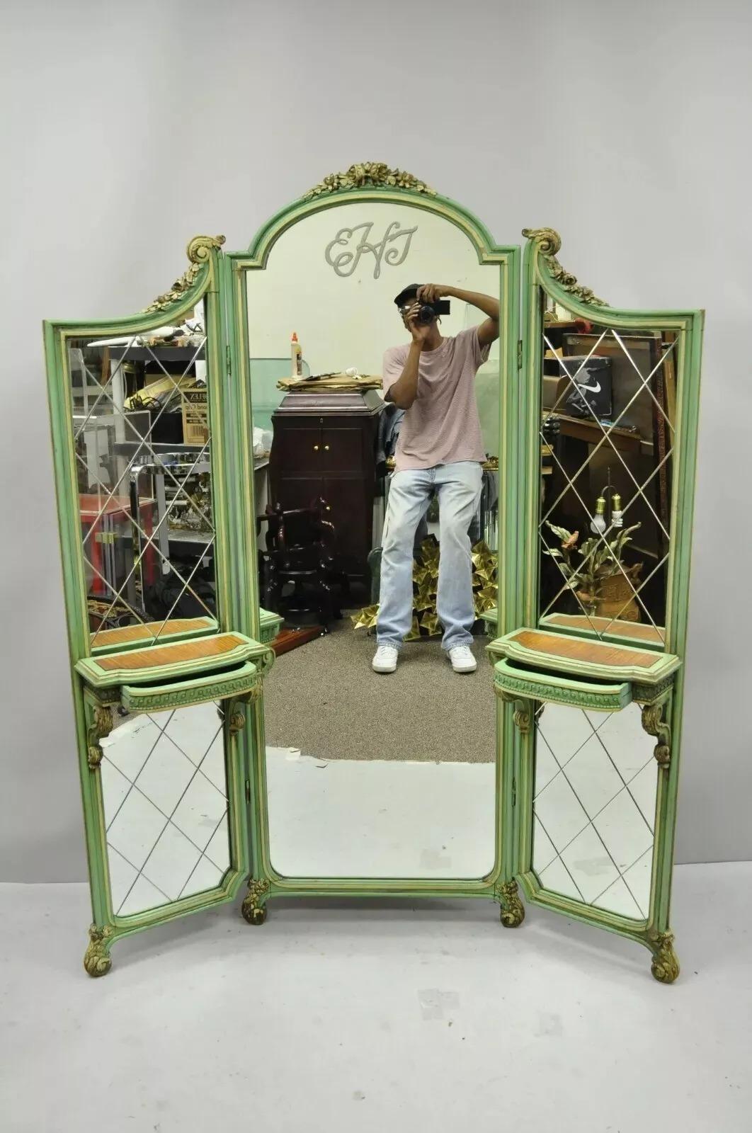 Antique French Louis XV Green Gold 3 Panel Folding Dressing Vanity Screen Mirror. Item features 2 small dovetailed drawers, etched glass panels, monogram to top center panel, green distress painted finish, three folding sections, very nice antique
