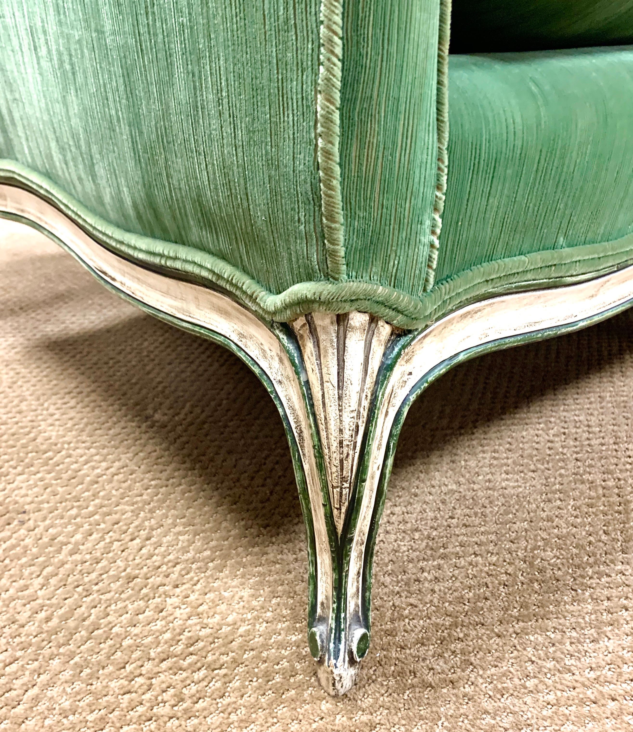Stunning 19th Century French Louis XV style wooden three-seat sofa with cabriole legs and luxurious green velvet upholstery. The sofa has a distressed cream painted frame and down filled seat cushion.