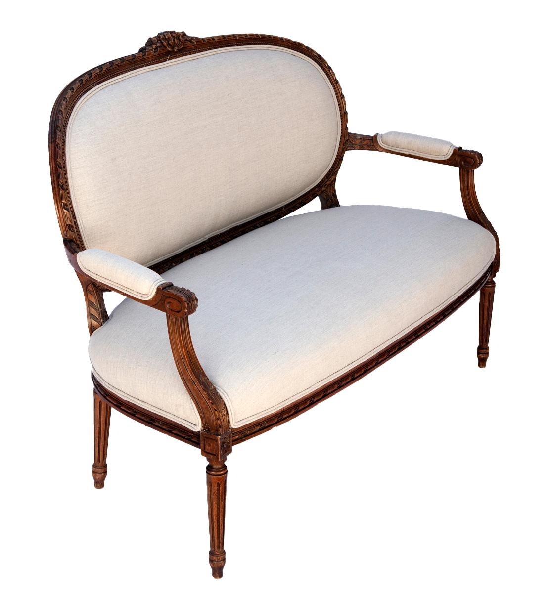 Ce canapé ancien en noyer Louis XV est le choix idéal pour une niche confortable, un coin lecture ou une chambre à coucher.  
Sculpté à la main dans du noyer massif, il présente des accents floraux et feuillus sculptés sur la couronne, le tablier,