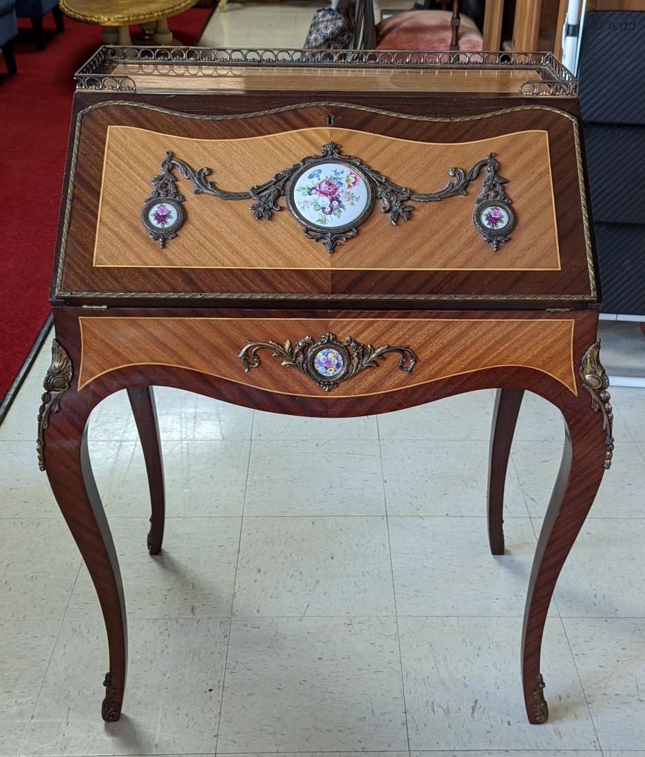 Lovely Ladies desk, French style, Top has ornate brass gallery, Mahogany case, Slant front, Beautiful handpainted porcelain pieces on front and sides, Inlay, Brass ormolu accents, Rest on cabriole legs, writing surface has leather inlay,