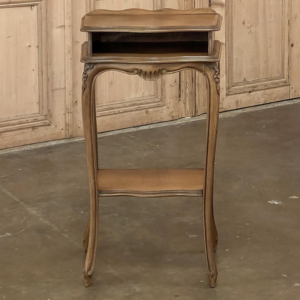 Antique French Louis XV maple end table is an elegant and slightly unusual piece, providing three surfaces in sublime style! The top edge is subtly beveled and contoured, with a short rail across the back to keep things in place. A shelf immediately