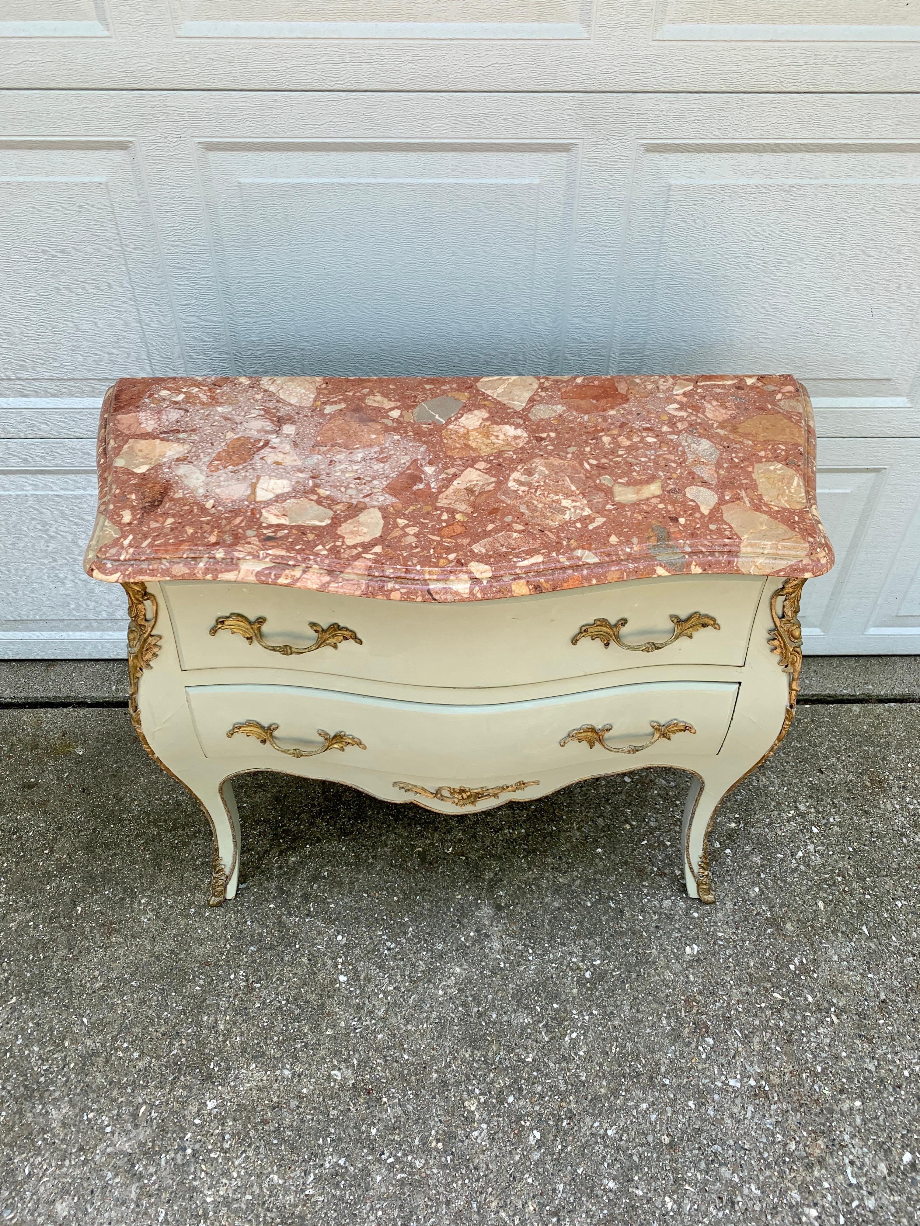 A gorgeous antique French Bombay commode or chest of drawers
France, Early 20th century
Painted wood in a lovely light green color, with mounted bronze ormolu, and beveled pink, red, and tan marble top.
Measures: 37.75? W x 16 D x 30.75 H.
Good