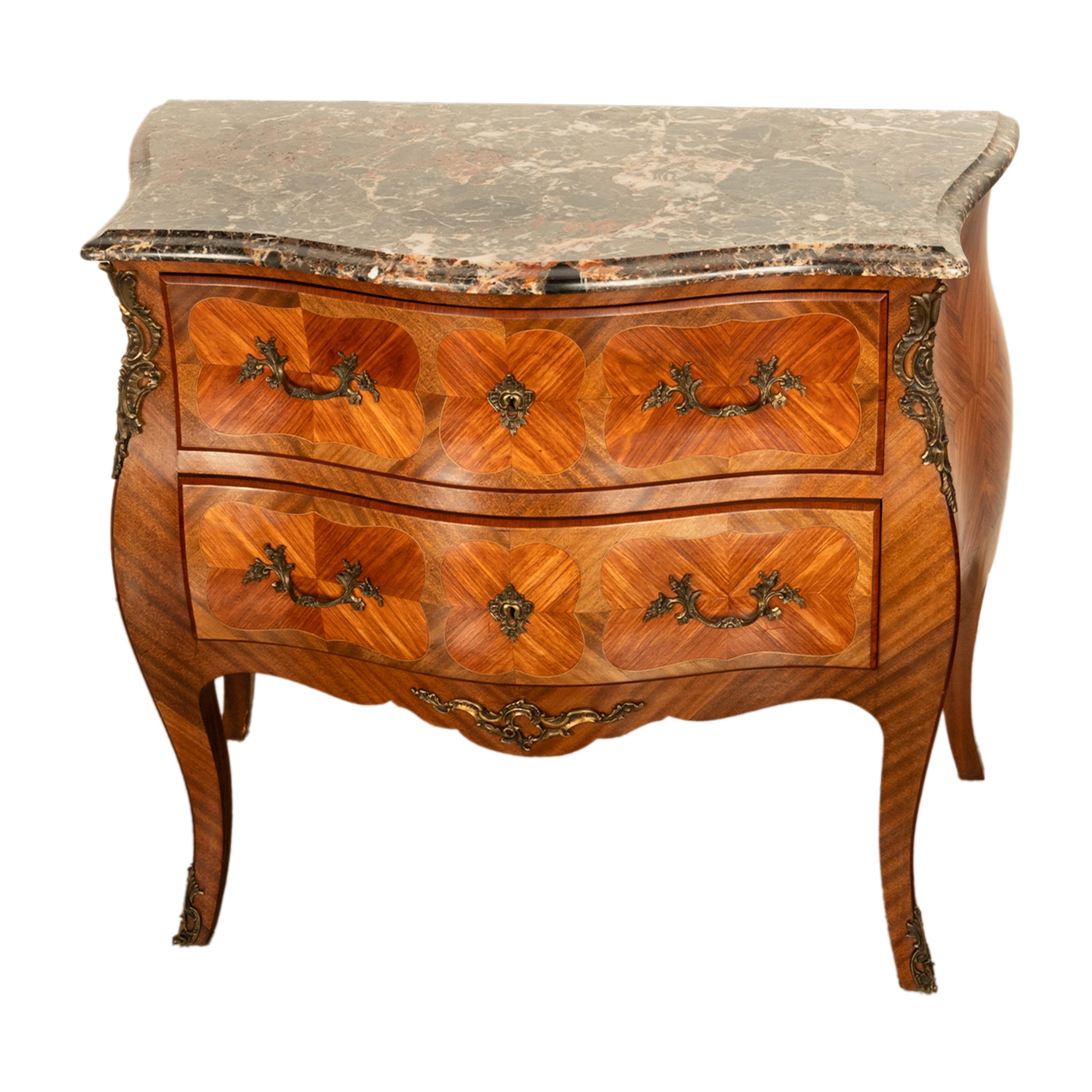 Un'antica cassapanca di qualità in stile Luigi XV con piano in marmo e ormolatura in legno di tulipano e kingwood a forma di bombe, circa 1900.
Il piano a forma di serpentina ha l'originale marmo variegato verde e marrone ruggine, la cassettiera ha