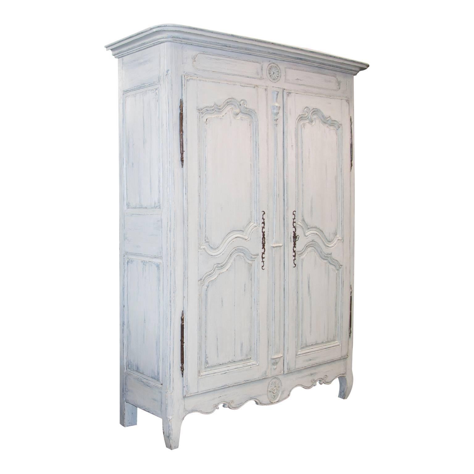 A very exceptional and rare Bordelais Armoire cupboard from the French Louis XV period in a light blue patina finish. The cabinet opens with two beautifully paneled doors, which are enclosed by rich carvings and exceptional panels. The wood of the