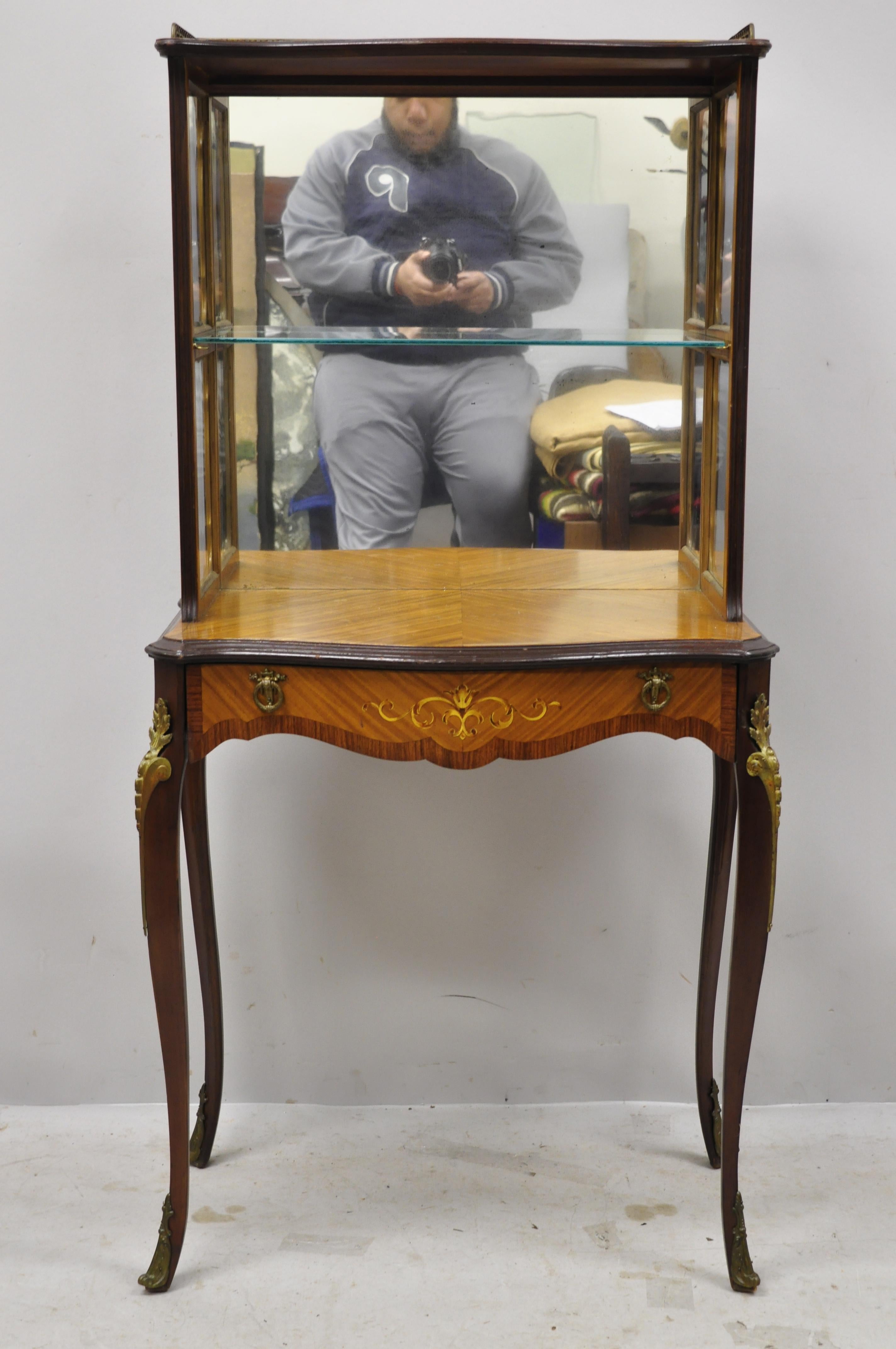 Antique French Louis XV small Petite Curio étagère stand with satinwood inlay and one-drawer. Item features a mirror back, bronze ormolu, satinwood inlay, nice petite size, small impressive form, 1-drawer, 1 glass shelf, cabriole legs, tapered legs,