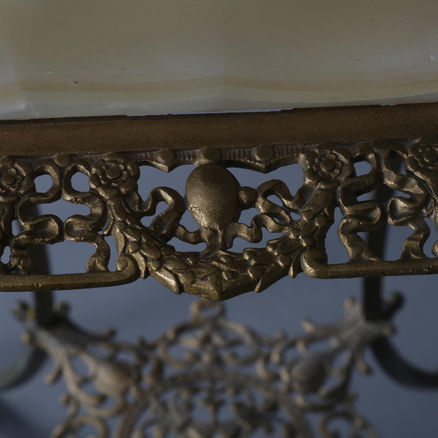 Antique French Louis XV plant stand features brass construction with onyx top seated in pierced foliate and garland frame and raised on fine cabriole legs terminating in acanthus form feet and having lower pierced display shelf, circa