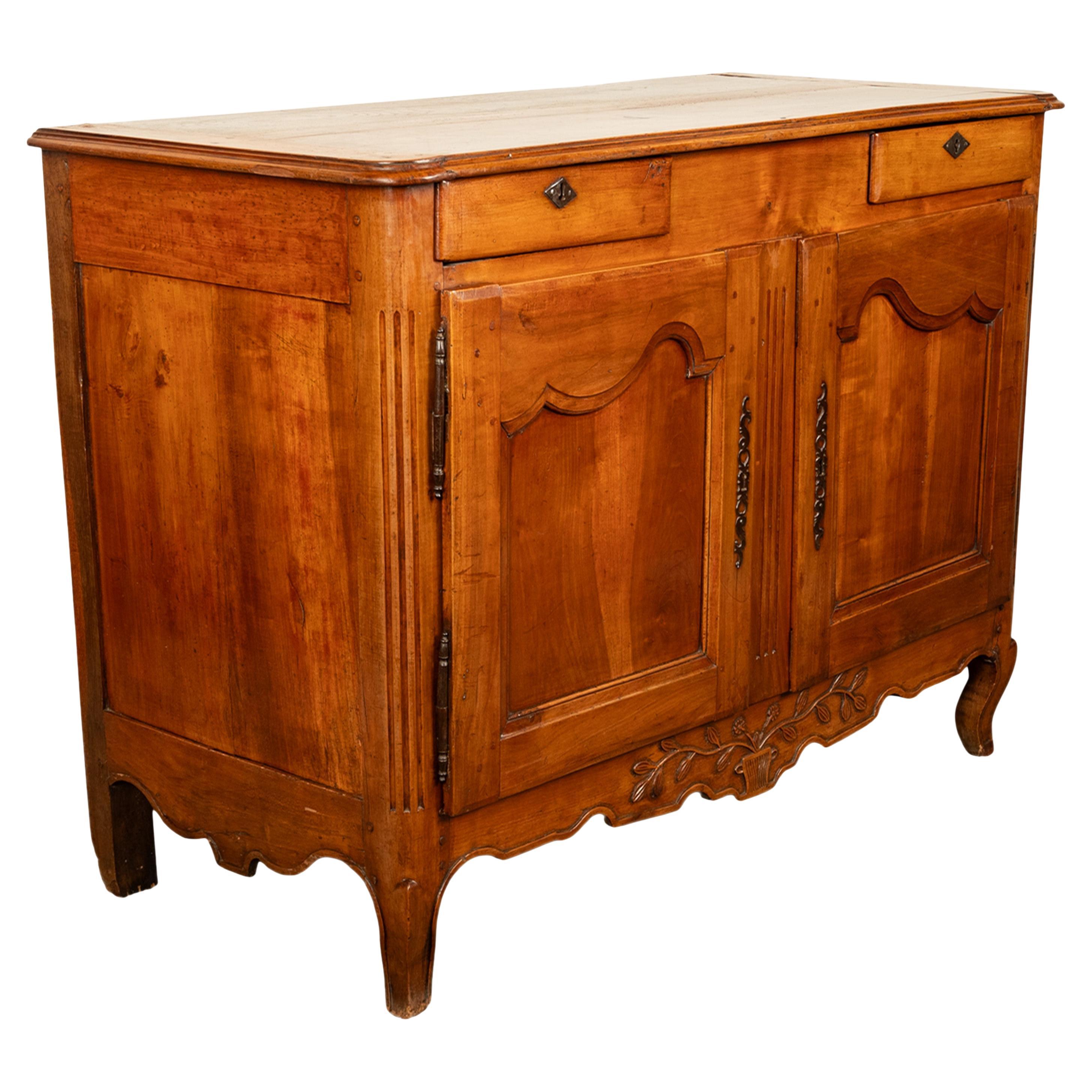 Un ottimo mobile da buffet in noce intagliato di epoca provinciale francese, circa 1820.
Il buffet ha un bordo modanato con due cassetti sottostanti ciascuno con una serratura a forma di losanga in ferro, sotto ci sono un paio di porte a pannelli