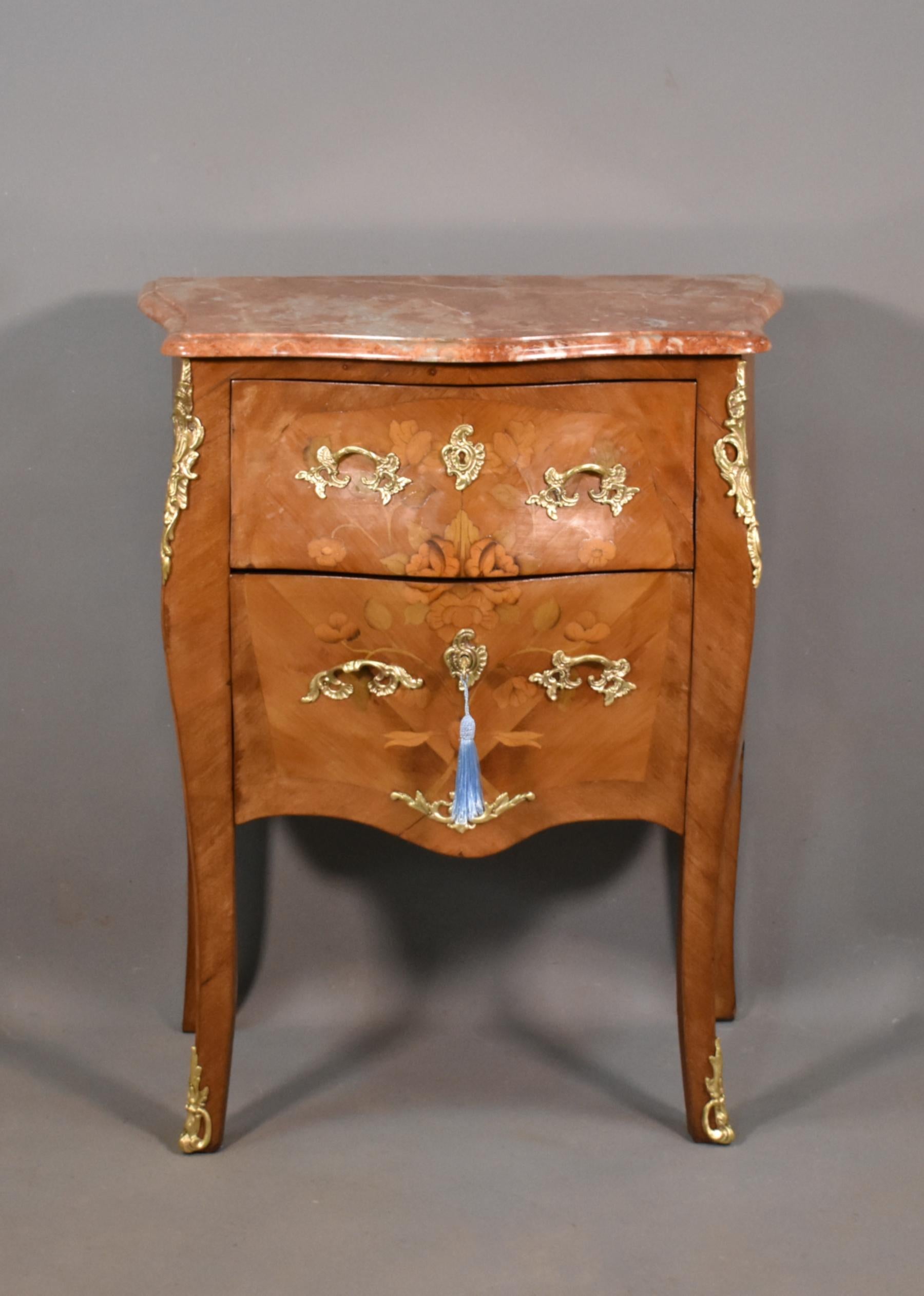 Antique French Louis XV Revival Marquetry Commode 

This delightful commode features a free-standing variegated marble top with a serpentine front and carved moulded edge. 

In the style of Revel, a town well-known for prolific manufacture of