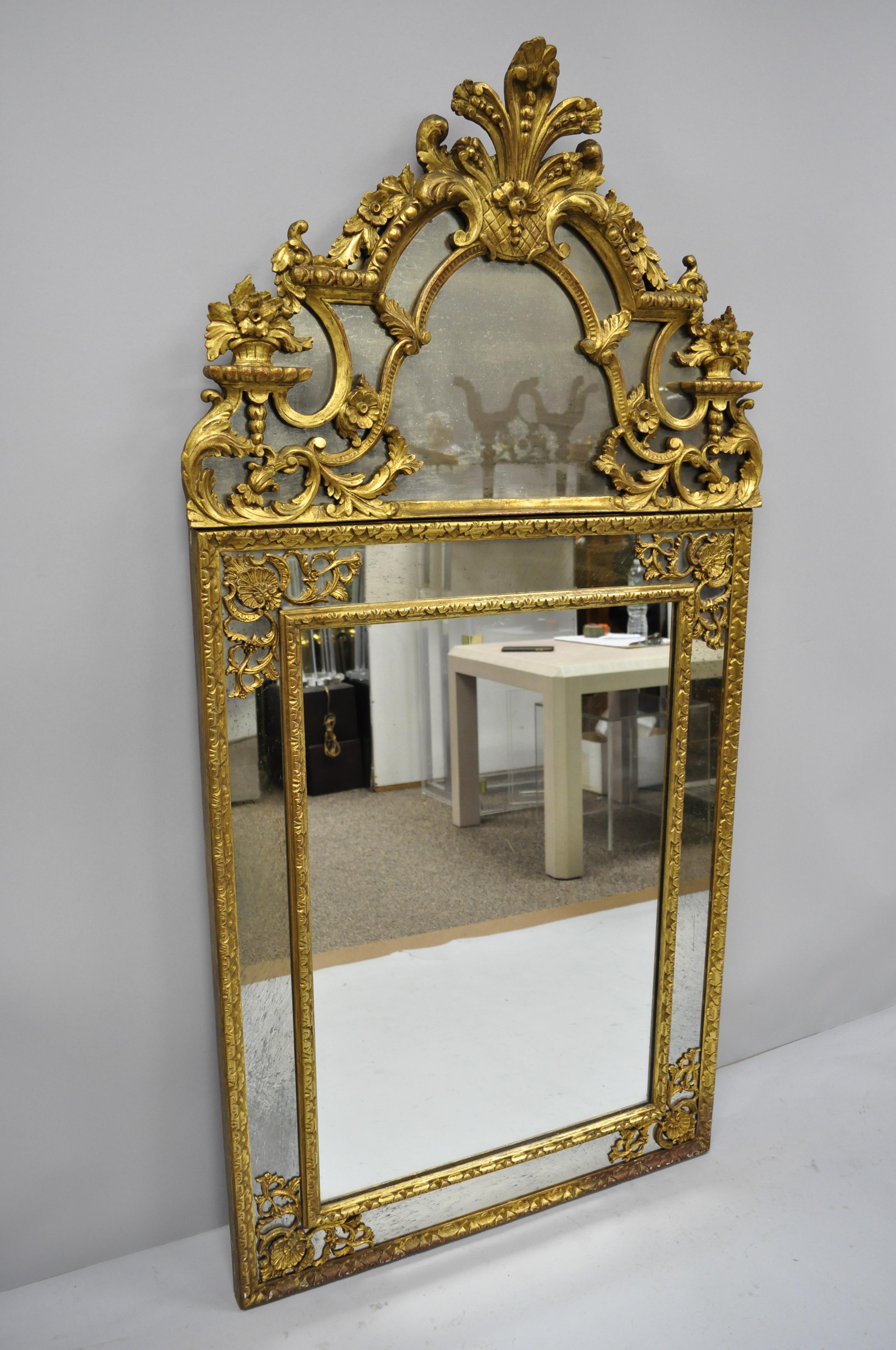 Antique French Louis XV Rococo Style gold trumeau console wall mirror. Item features aged glass to upper crest mirror, ornate floral and leafy scroll work, very impressive form, circa early 20th century. Measurements: 60