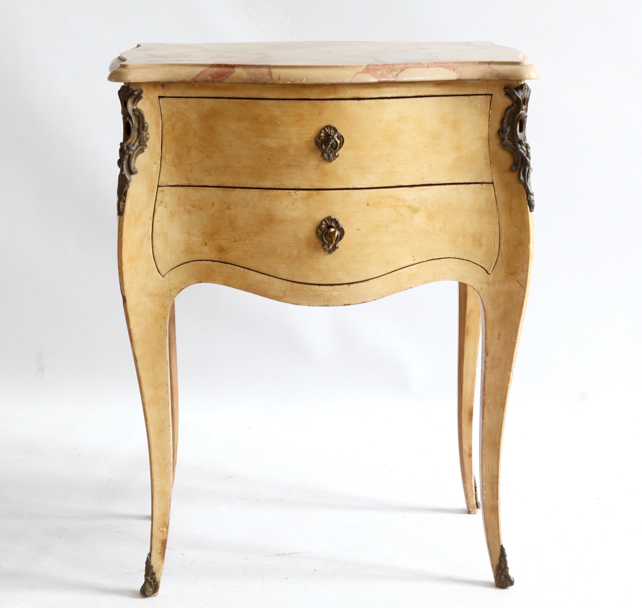An early to mid-20th century French, Louis XV style, 'bombe' bedside table/small chest with its original beveled marble top in a warm yellow ochre and rose palette, complete with the original, decorative, bronze ormolu, including keys with locks,