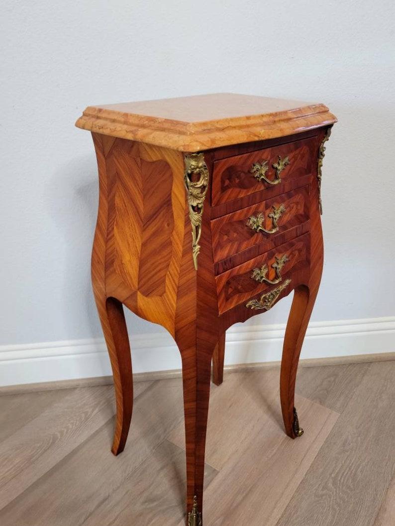 This is a stunning antique French kingwood marquetry Louis XV style bombe chest nightstand. circa 1920.

At the time of writing this, we have a similarly styled near match available listed separately (shown in photos of the two). If you would like