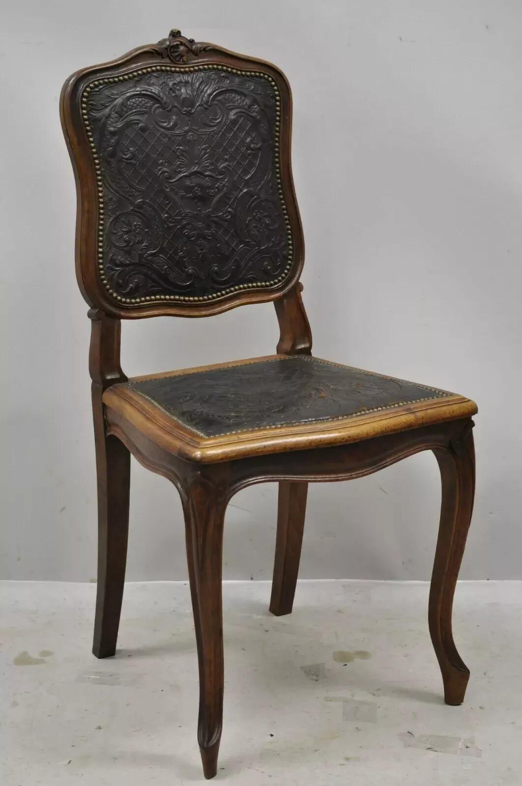Ancienne chaise de salle à manger en noyer, en cuir gaufré brun, de style Louis XV (C). Cet article présente un dossier et une assise en cuir gaufré marron, une garniture de têtes de clous, un cadre en bois massif, des détails finement sculptés, des