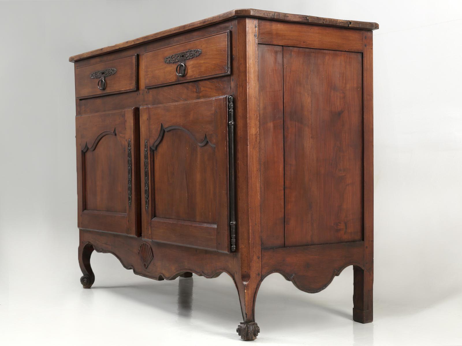 Antique French Louis XV style buffet constructed from solid French cherrywood, with stylized shell carving on a scalloped apron. Our antique French Louis XV style buffet, was restored in France before being shipped to the states. This antique French