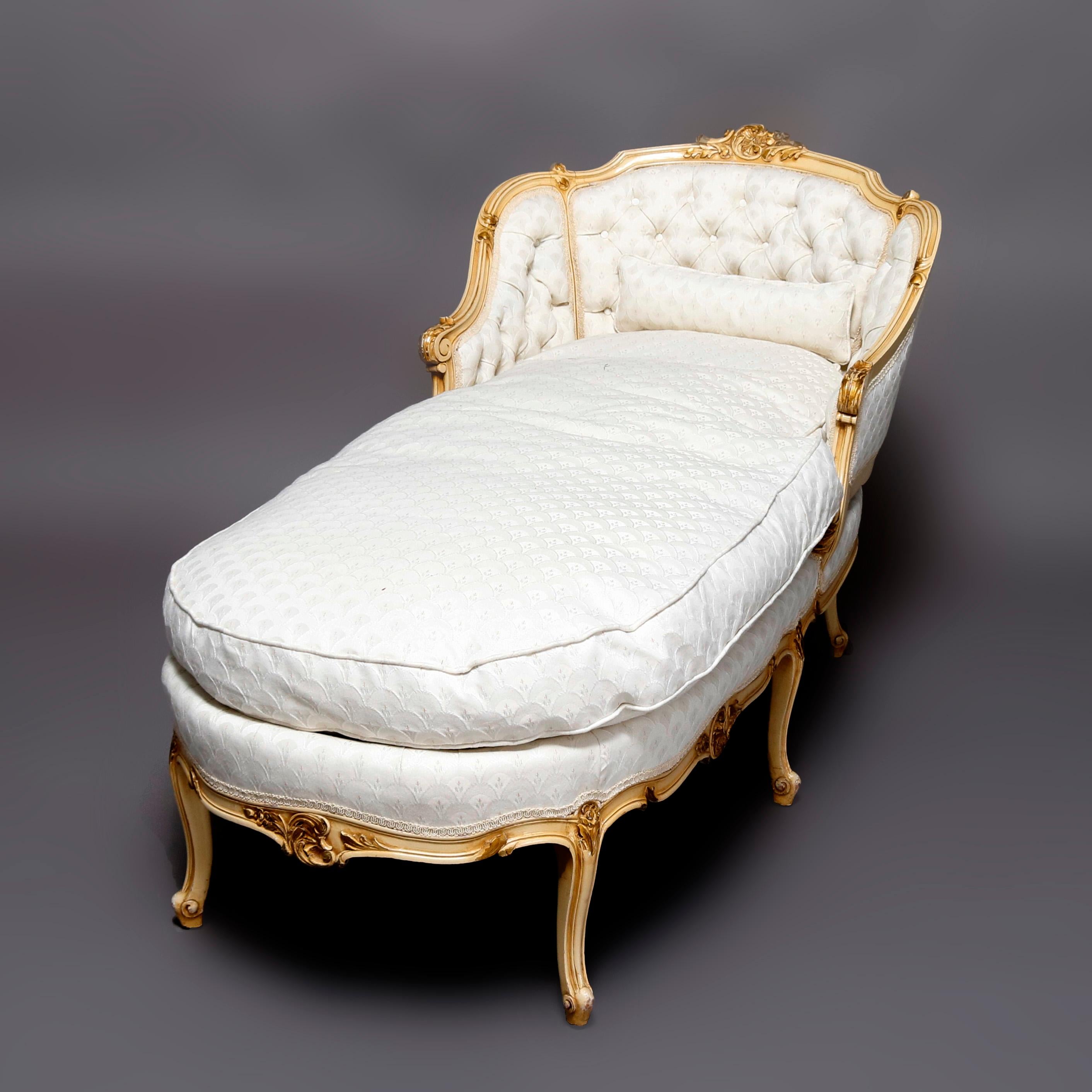 An antique French Louis XV style Recamier offers painted and gilt carved scroll form wood frame having shell and foliate form crest and accents, curved back with scroll arms and legs, upholstered with button back and arms, circa 1830.

***DELIVERY