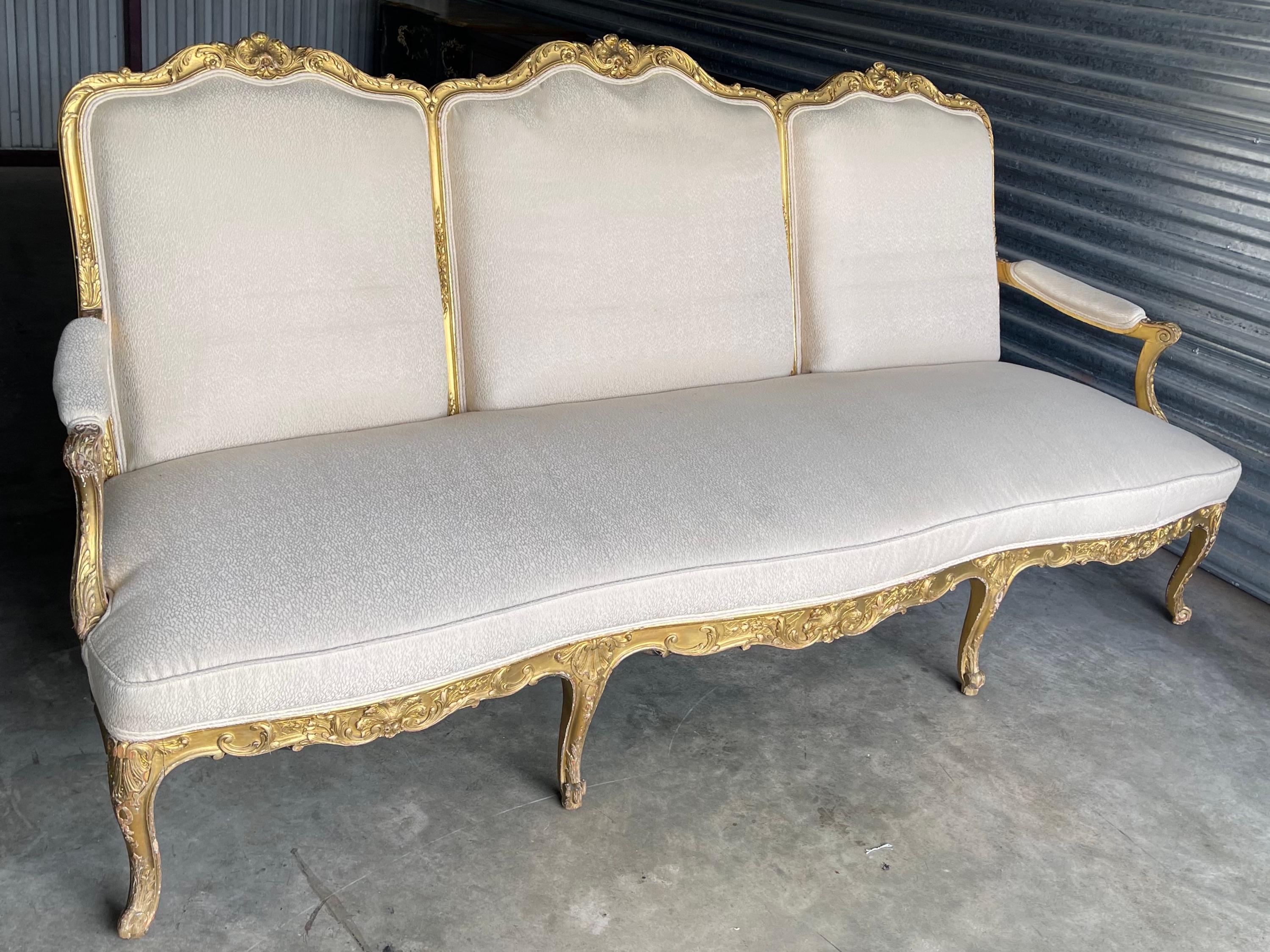 Dies ist eine schöne antike Französisch Louis XV-Stil geschnitzt Vergoldung Sofa. Beachten Sie die geschnitzte Muschelrückseite! Der Vintage-Stoff weist einige Gebrauchsspuren auf, ist aber ohne Löcher.
