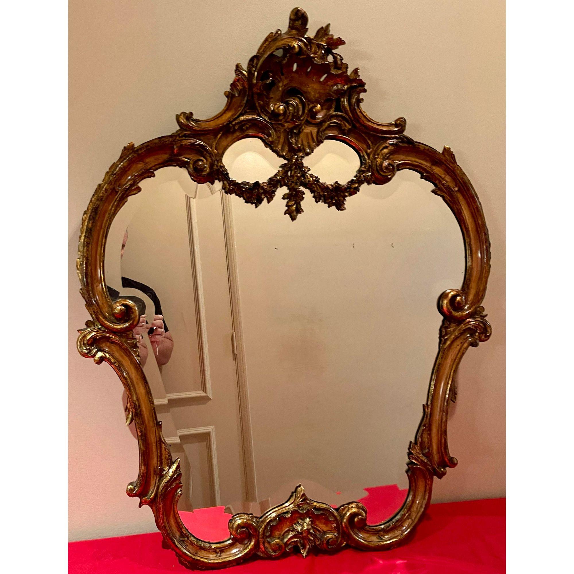 Antique French Louis XV style carved walnut mirror. It is an exquisite example and features gilt highlights in a walnut frame. French maker's mark on the back, Bardie in Paris.

Additional information: 
Materials: Mirror, Walnut
Color: