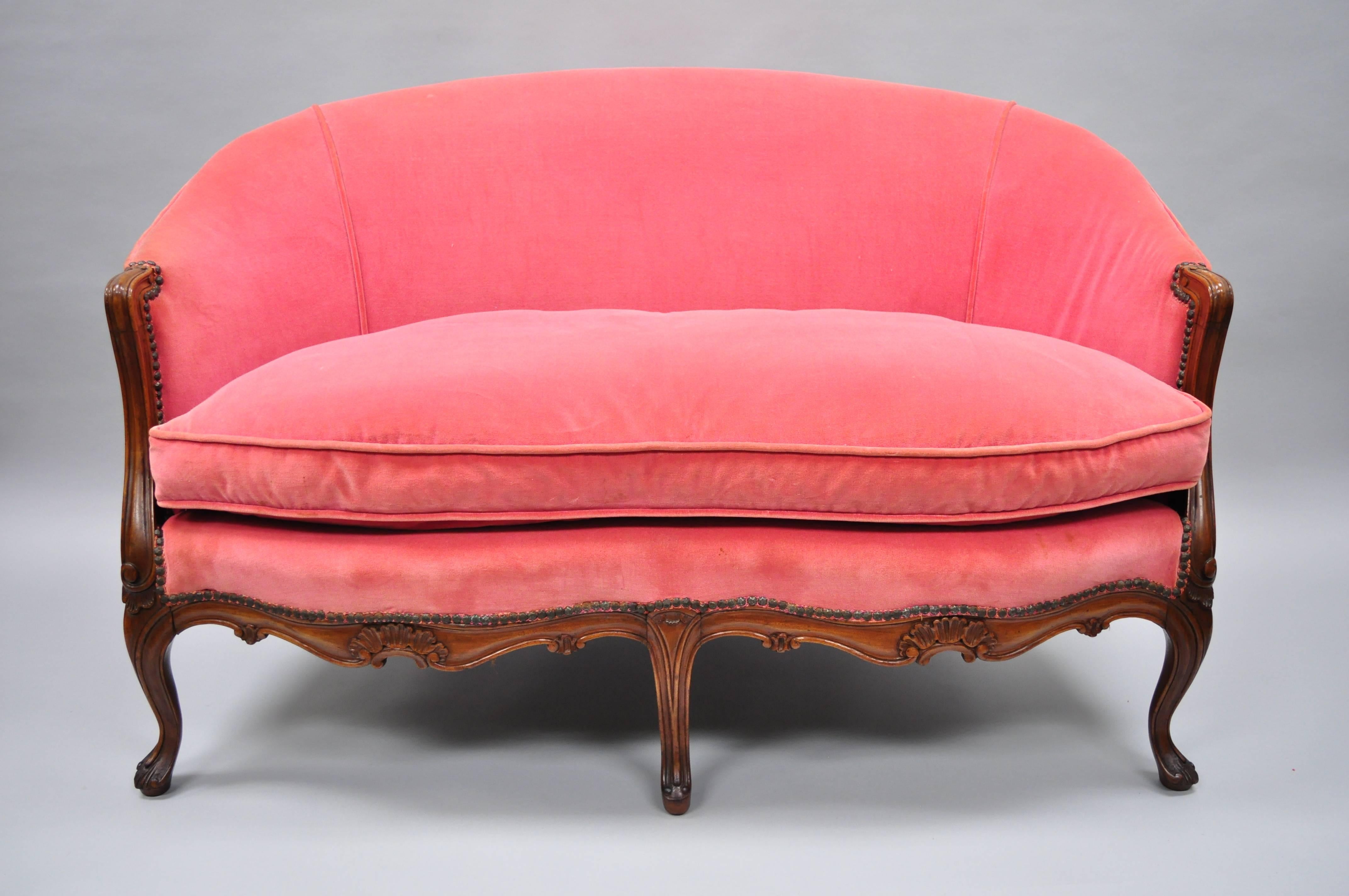 Antique French Louis XV style carved walnut settee. Features shapely oval frame, partial down filled cushion, solid wood construction, nicely carved details, cabriole legs, great style and form, circa 1920s. Measurements: 32.5