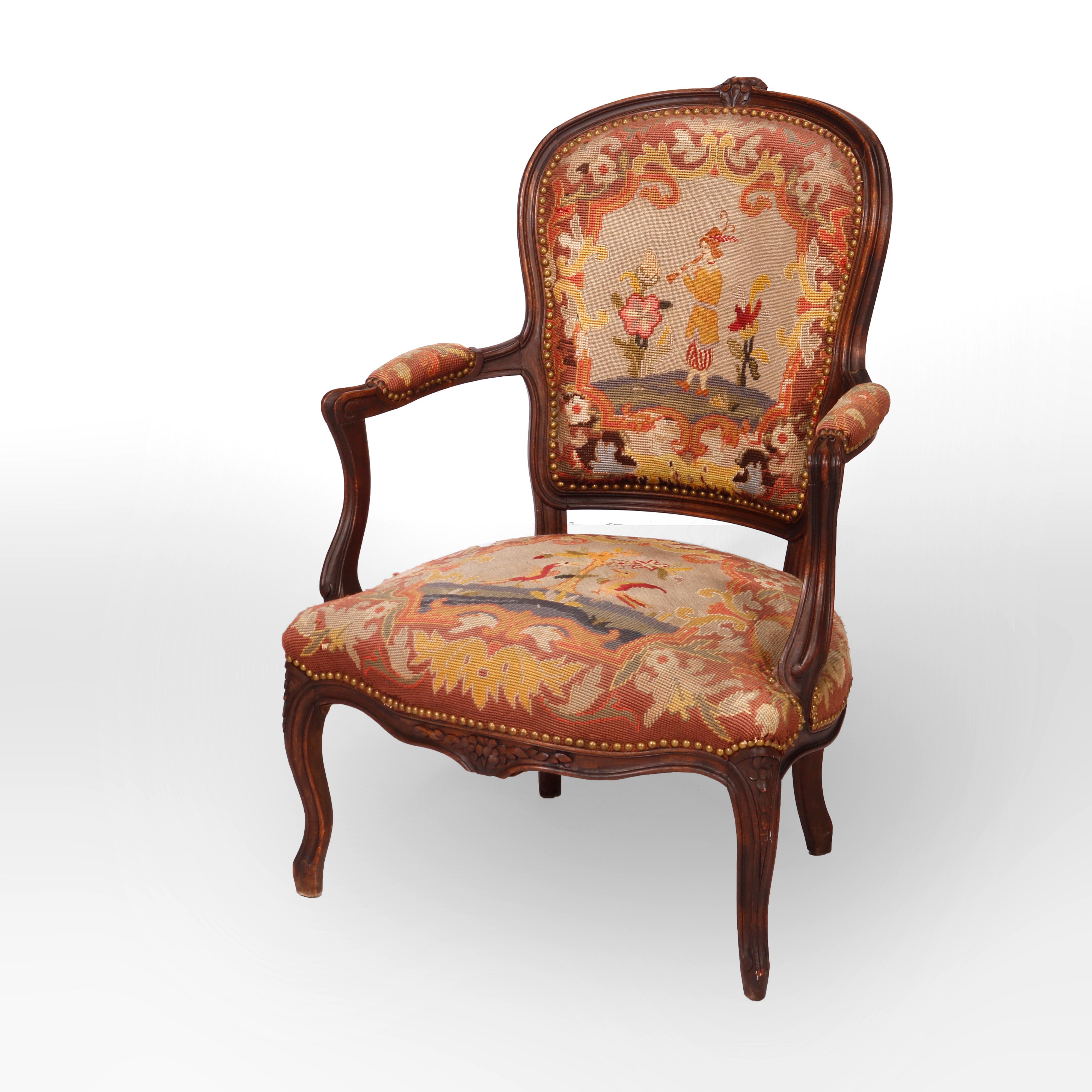 An antique French Louis XV stye armchair offers walnut frame with carved foliate crest over tapestry back and seat, raised on cabriole legs, c1900

Measures - 37.5''H X 25.5''W X 26.5''D