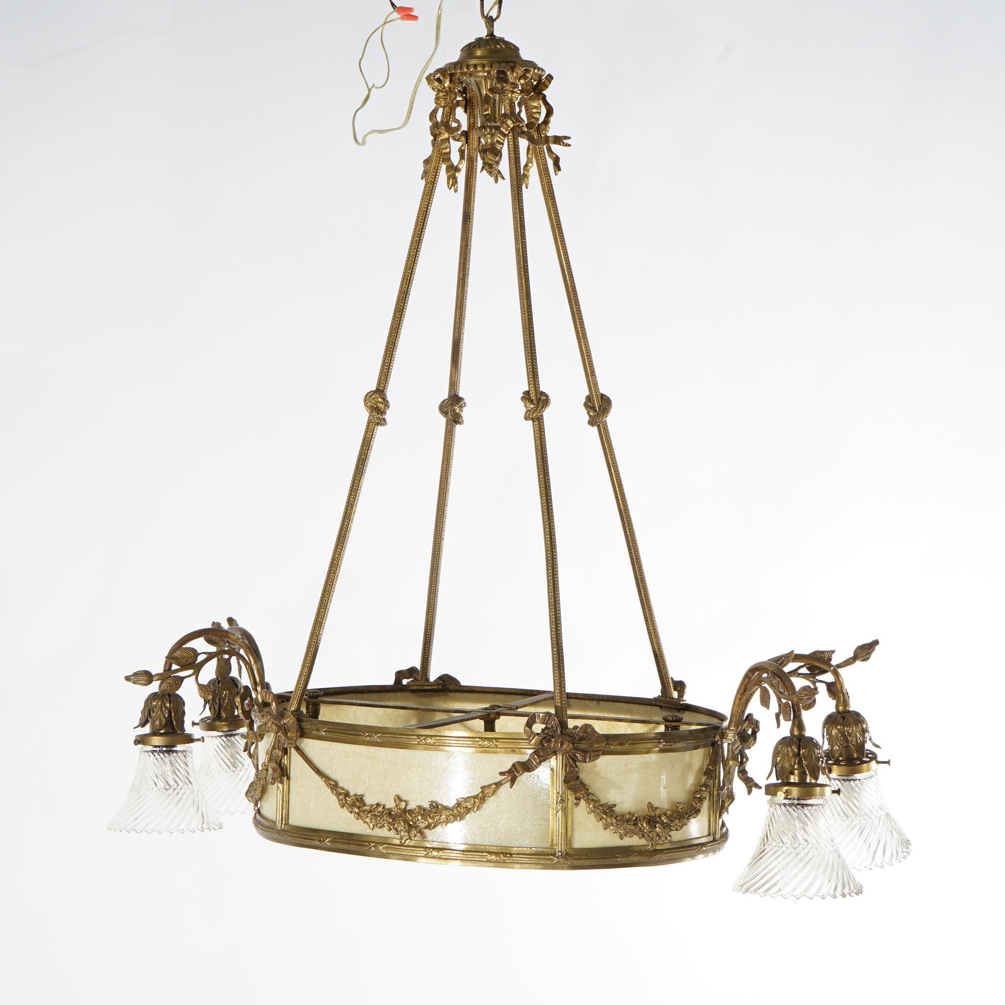 Un antico lampadario francese a sei luci in stile Luigi XV presenta una struttura in bronzo dorato con gocce a forma di corda annodata, un inserto in mica con due luci interne, quattro bracci a forma di voluta che terminano con luci con paralumi in