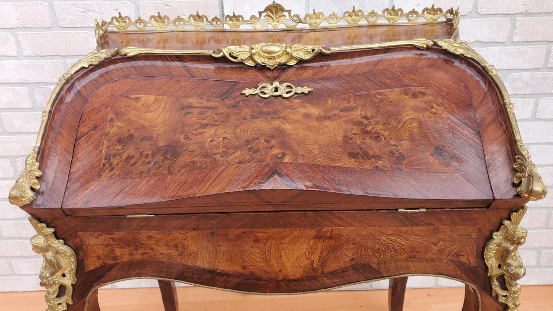 Antique French Louis XV Style Gilt Bronze Mounted Bureau De Pente Writing Desk

Questo antico scrittoio francese in stile Luigi XV con montatura in bronzo dorato è caratterizzato da un'impiallacciatura in mogano e da una struttura in legno