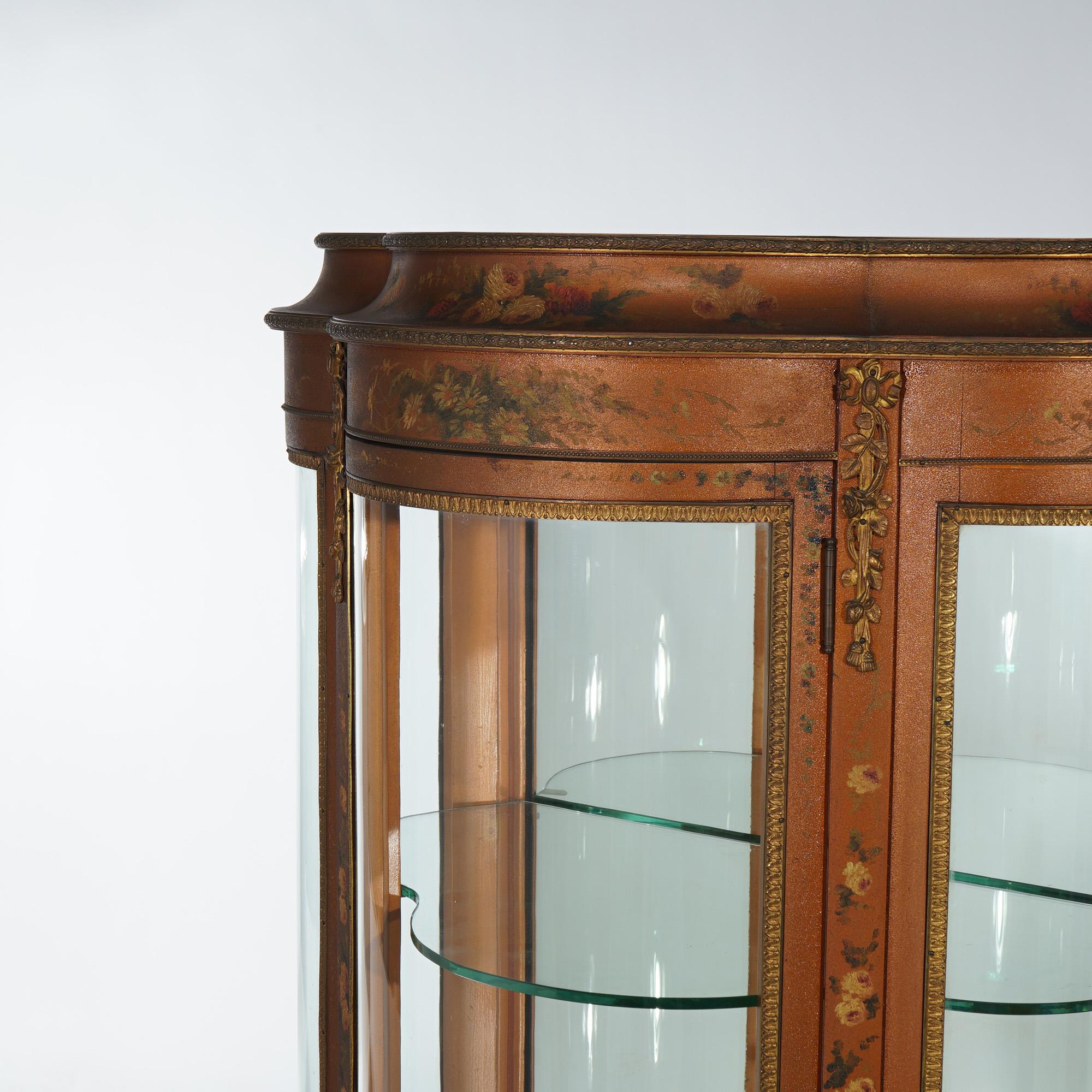 An antique French Louis XV style display vitrine offers mahogany construction in clover leaf form with curved glass, single door, mirrored back, hand painted floral decoration, and raised on cabriole legs, circa 1890

Measures - 55