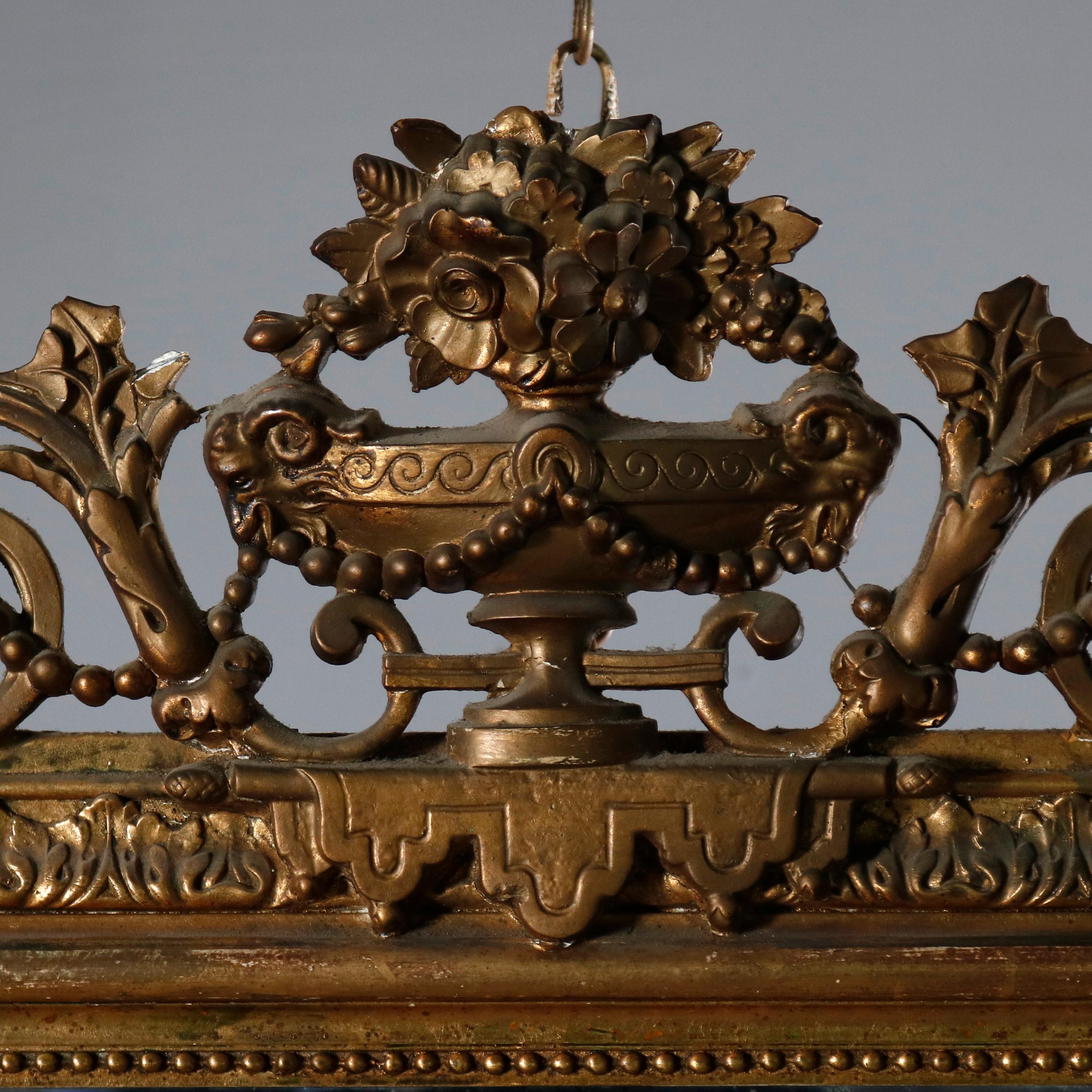 An antique French Louis XV style over mantel mirror offers giltwood frame with pierced crest having central panier de fleurs (urn of flowers) flanked by scroll and foliate decoration, corners with floral and foliate corners, circa 1870

Measures: