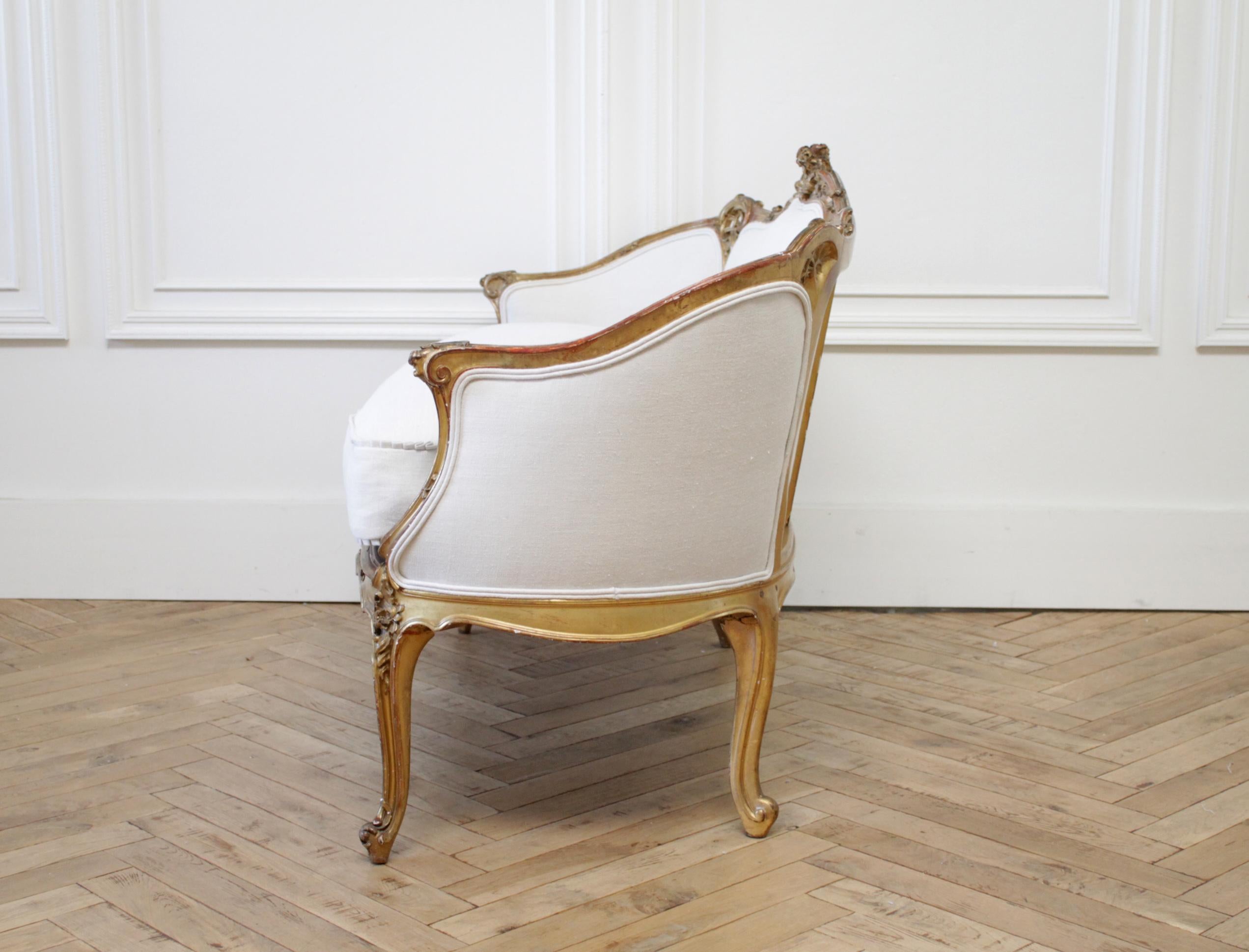 Antique French Louis XV style giltwood settee with linen slip cover down cushion
Original giltwood linen settee with an aged patina finish. We've reupholstered this in a light pre softened Irish Linen. The seat is a slip cover with zipper to remove