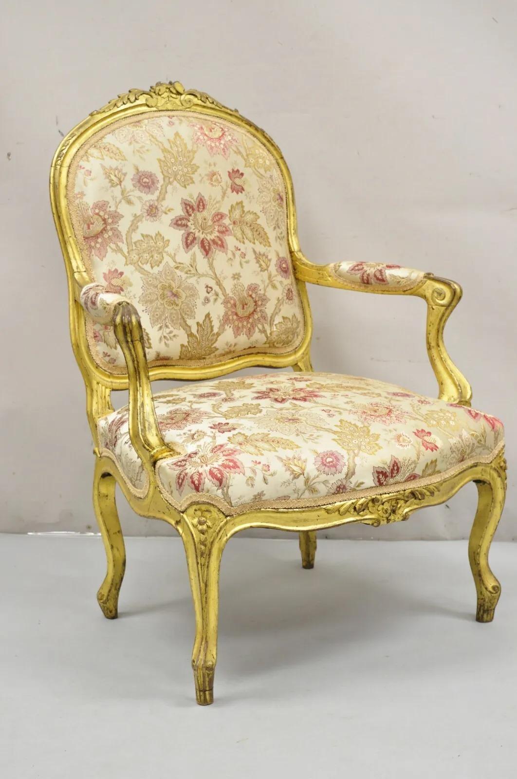 Antique French Louis XV Style Gold Giltwood Floral Carved Upholstered Arm Chair. Item features a carved gilt wood frame, distressed gold finish, floral print upholstery. Circa 19th Century Measurements: 39