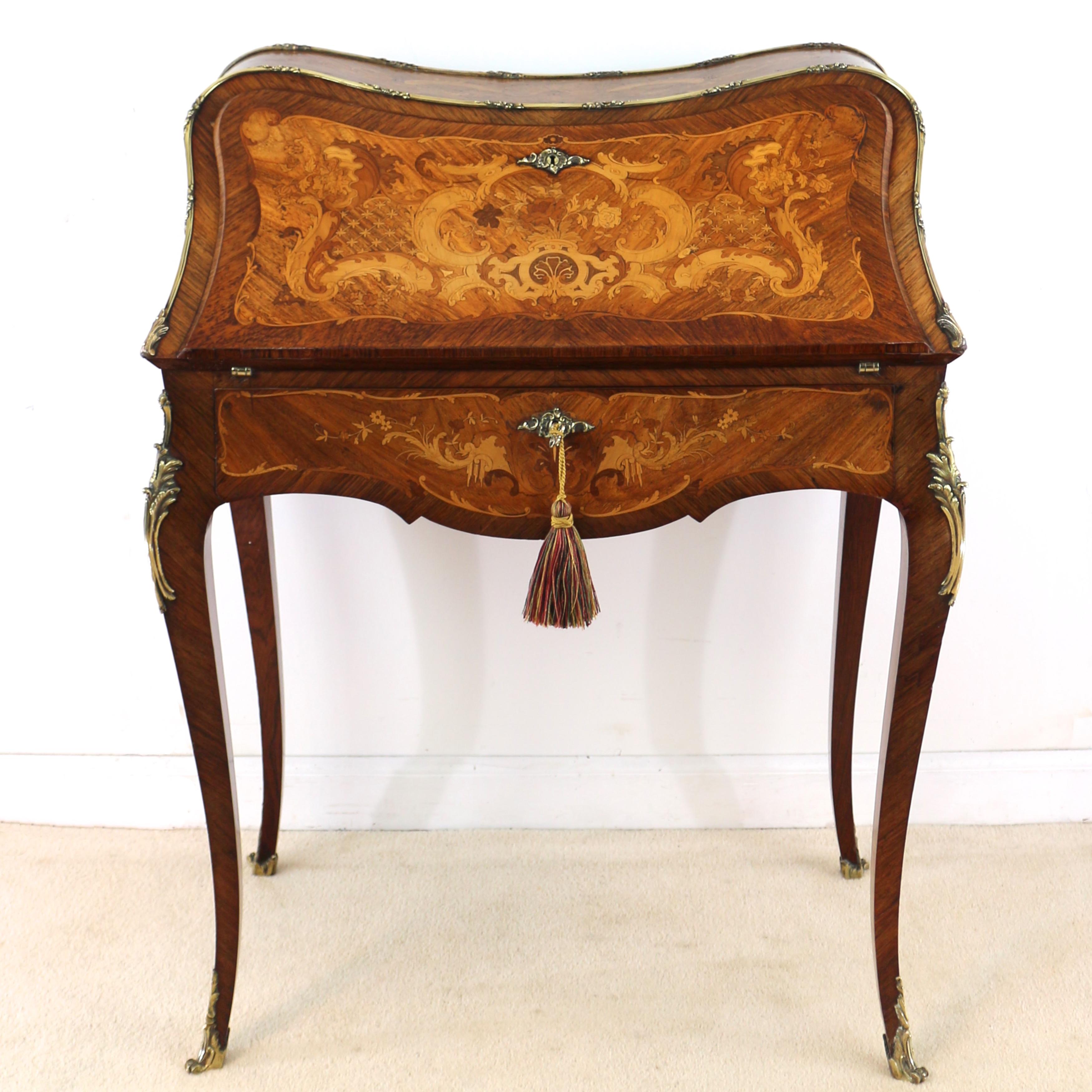 A very attractive late 19th century French Louis XV Rococo style kingwood and marquetry bureau de dame retailed circa 1900 by the renowned firm S & H Jewell of London. Of bombé form and profusely inlaid with scrolling acanthus leaf and floral