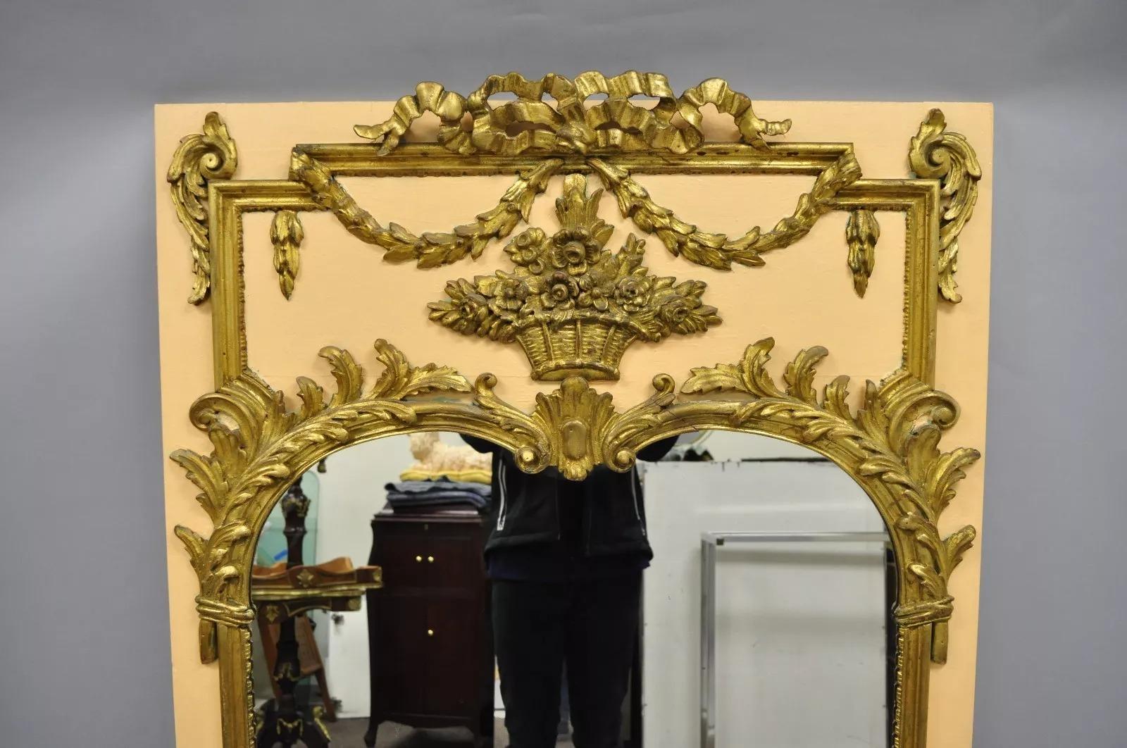 Antique French Louis XV Style Giltwood Trumeau Wall Mirror in Peach & Gold. L'articolo presenta una finitura color pesca e oro, un bouquet in legno intagliato, un drappeggio e delle volute di foglie d'acanto, una cornice in legno massiccio, dettagli