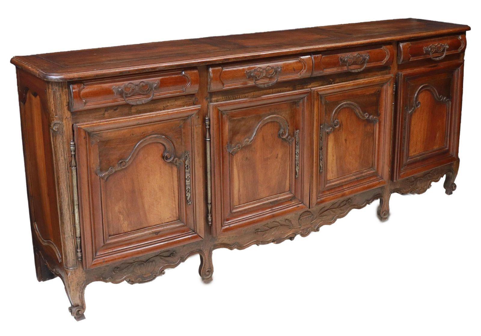 Large and tall French Provincial Louis XV style walnut sideboard, early to mid 19th c.. This sideboard has four iron pull drawers over four paneled doors on exposed hinges, rising on whorl feet. Beautifully carved detail seen throughout. Note: iron