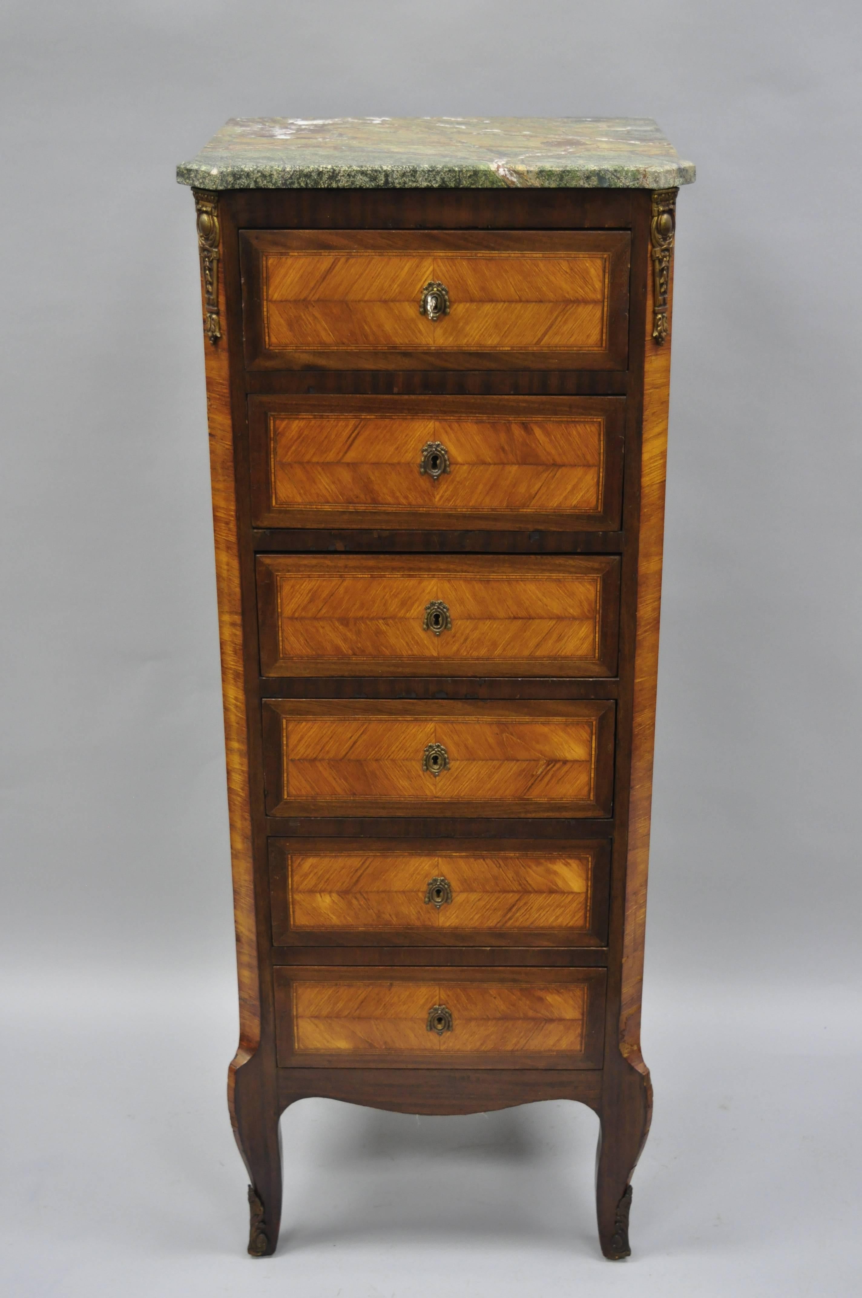 Antique French Louis XV style green marble top inlaid lingerie chest. Item features shaped green marble top, bronze ormolu, satinwood inlay, working lock and key, six dovetailed drawer, cabriole legs, early 20th century. Measurements: 50.5