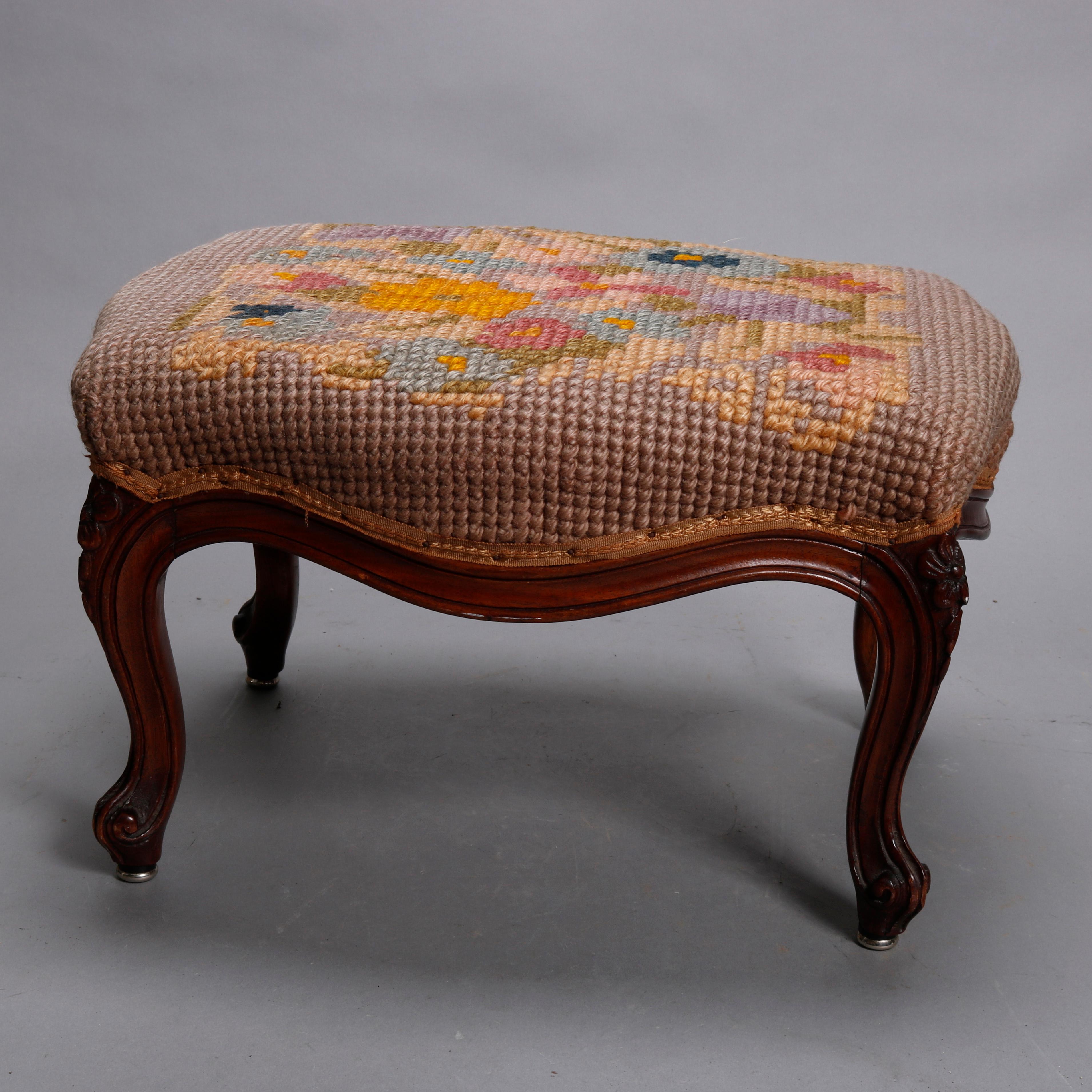 An antique French Louis XV style footstool offers floral needlepoint seat over shaped carved walnut frame, raised on cabriole legs terminating in scroll feet, circa 1900.

Measures - 11.5