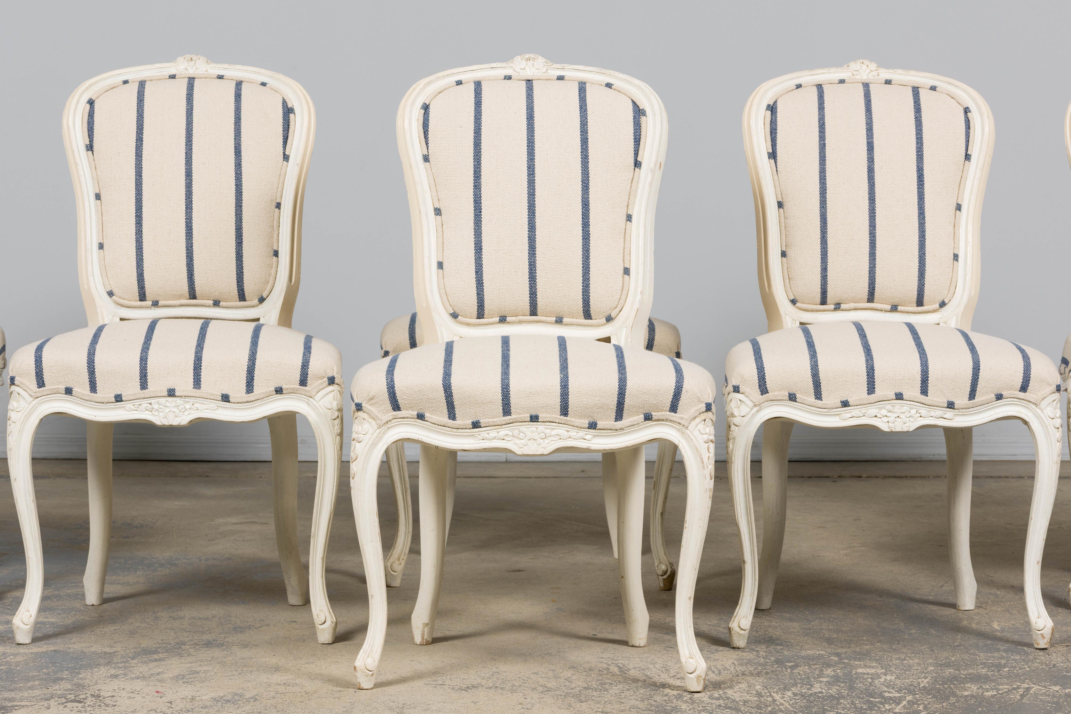 An exquisite restored set of eight late-19th-century French Provincial dining chairs in the Louis XV style, sourced in Provence. Hand-crafted from solid hardwood, the frames feature graceful serpentine lines, crisp floral crest carvings, finely