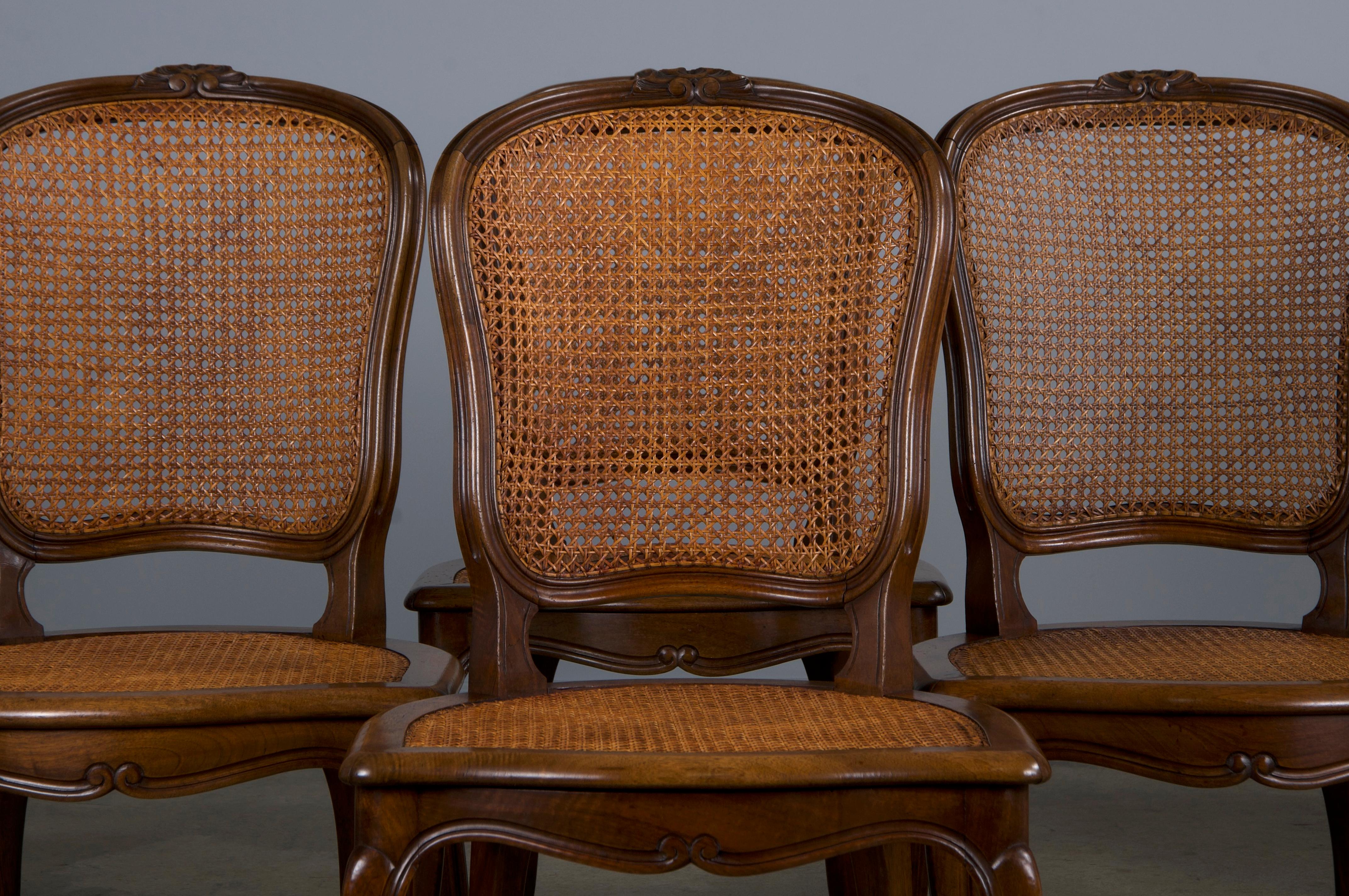 An elegant set of eight late 19th-century French Provincial dining chairs, crafted in the Louis XV style and sourced from Provence, France. These chairs are beautifully hand-crafted from solid walnut, featuring a naturally aged warm patina.