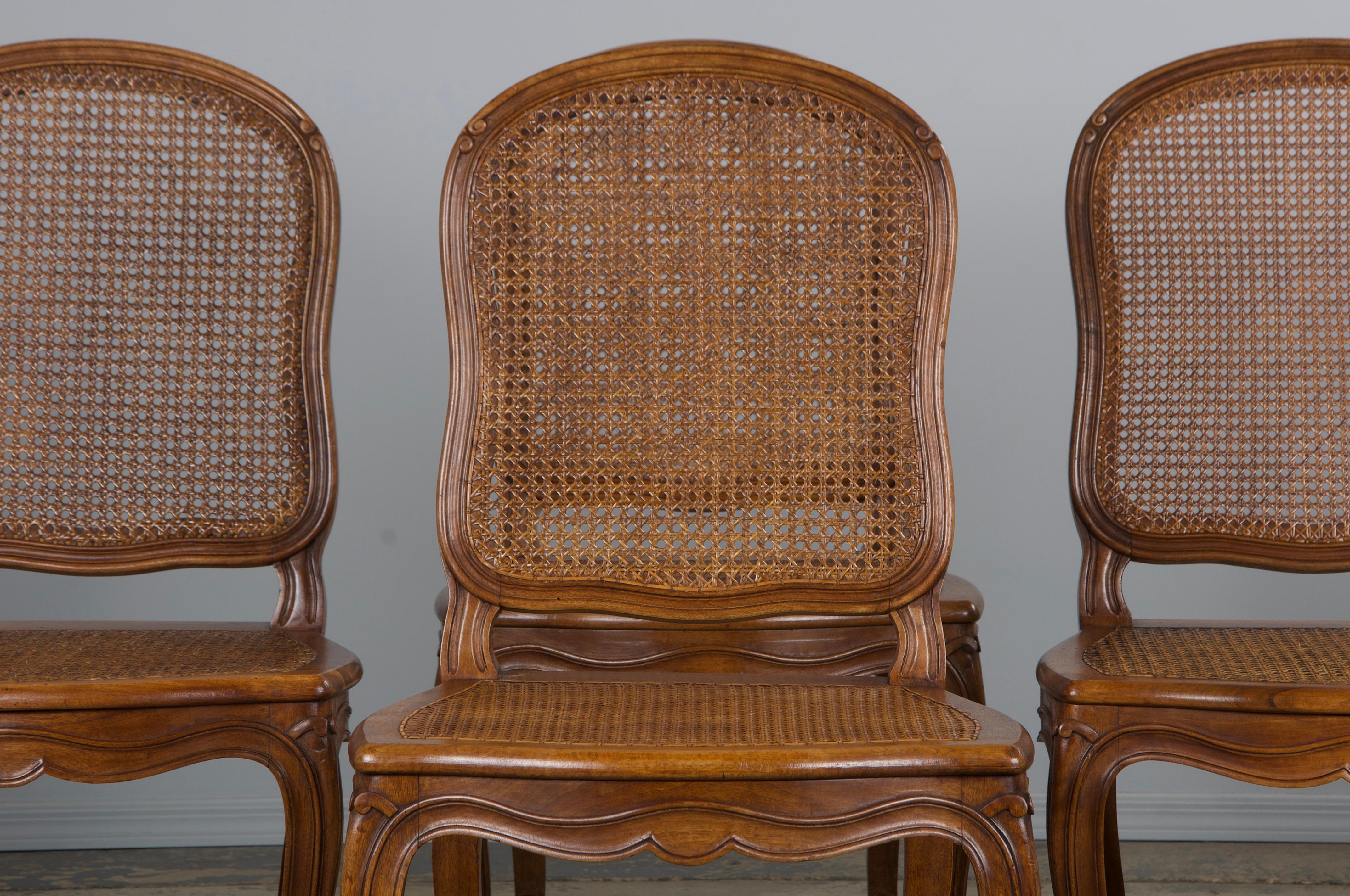 An elegant set of six late 19th century French provincial dining chairs made in the style of Louis XV and sourced directly from Provence, France. These chairs are beautifully hand-crafted from solid walnut, featuring a naturally aged warm patina.