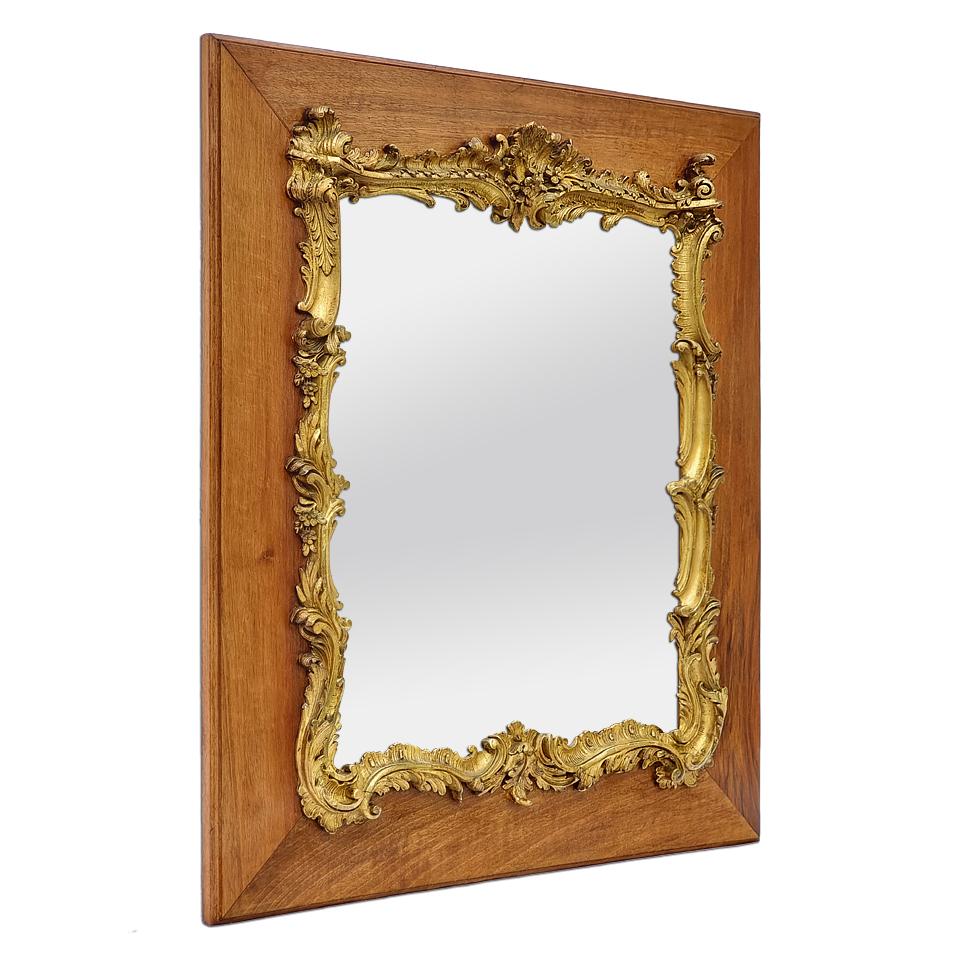 Miroir ancien de style Louis XV, vers 1890. Décoration en stuc doré de style rococo sur le bord du miroir en verre, monté sur un cadre en bois naturel. Feuilles à dorer en or mat et brillant. Largeur du cadre : 13 cm /  5.11 in. Miroir en verre