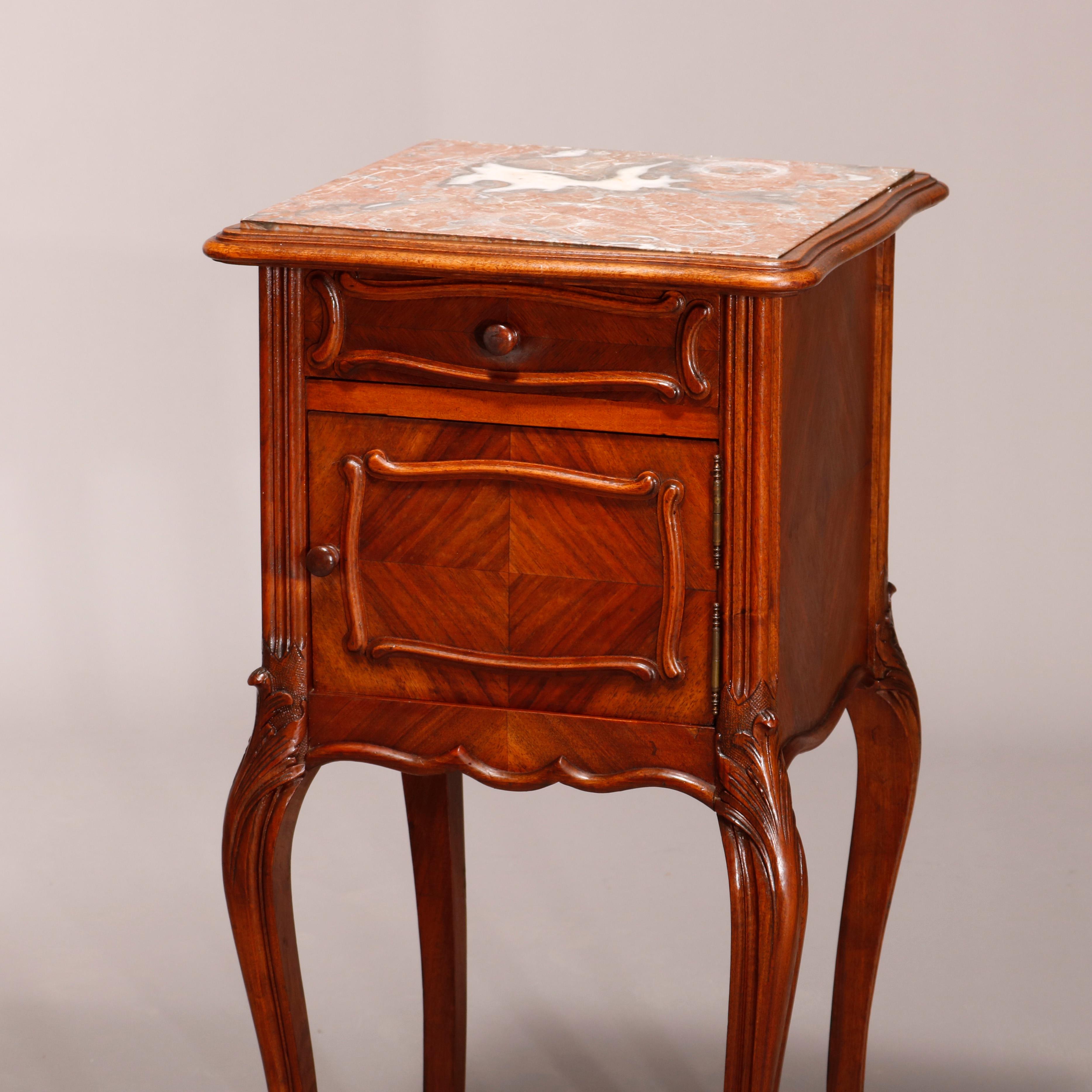 An antique French Louis XV style side stand offers walnut construction with inset marble top over single drawer and marble lined cabinet having bookmatched sides, raised on carved cabriole legs terminating in scroll feet, c1890.

Measures: 33.75