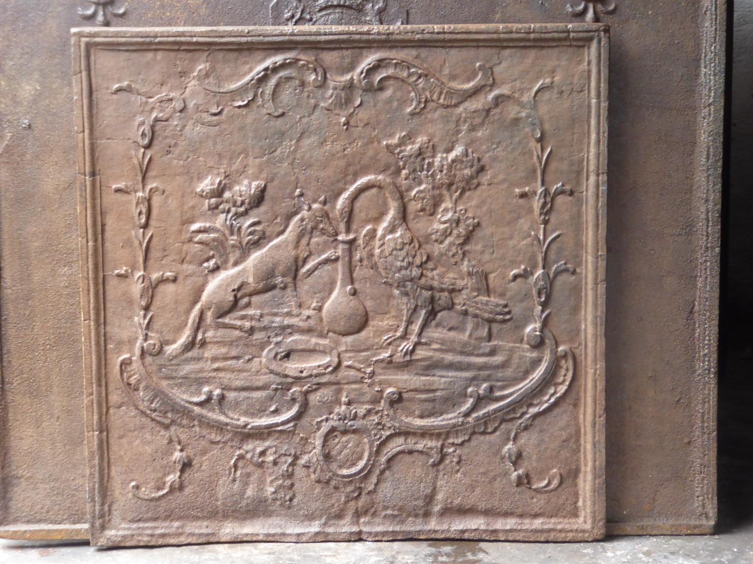 18th century French Louis XV fireback which depicts the fable of the fox and the stork (Jean de la Fontaine 1621-1695). The fox invites the stork to eat out. He gives him soup in a flat plate, so the stork in unable to drink anything. He leaves no