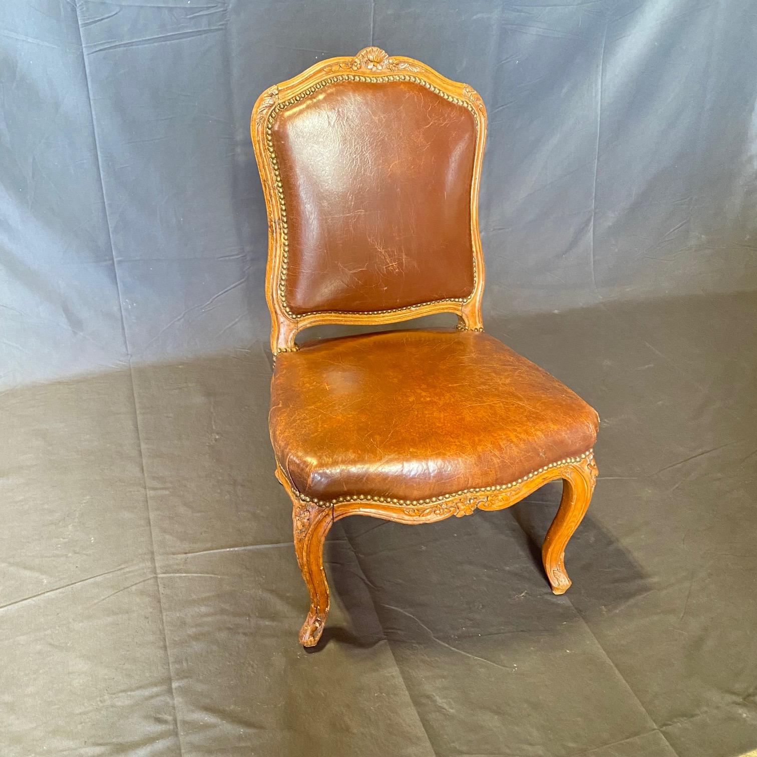 Ancienne chaise d'appoint Louis XV en noyer avec dossier et assise en cuir marron, garniture en tête de clou, cadre en bois massif, détails finement sculptés, pieds cabriole, vers le début des années 1900.
#7070