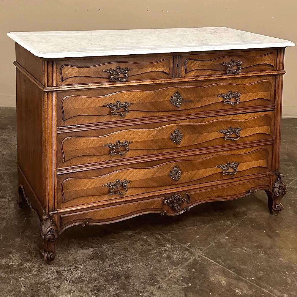 Antique French Louis XV Walnut Commode with Carrara Marble is the stylish way to provide both an elegant surface and convenient storage in any room!  The luxurious Carrara marble with subtle gray veining has a beveled edge around the rectilinear