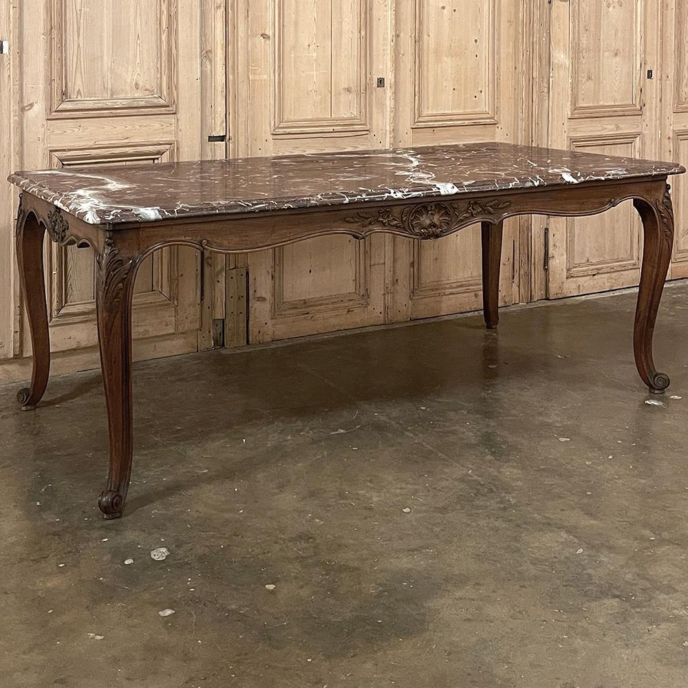 Antique French Louis XV walnut marble-top dining table is a truly unusual find! Sculpted from exquisite French walnut and luxuriously veined rouge marble, it combines the best of both worlds!  The undulating scrollwork of the apron and cabriole legs