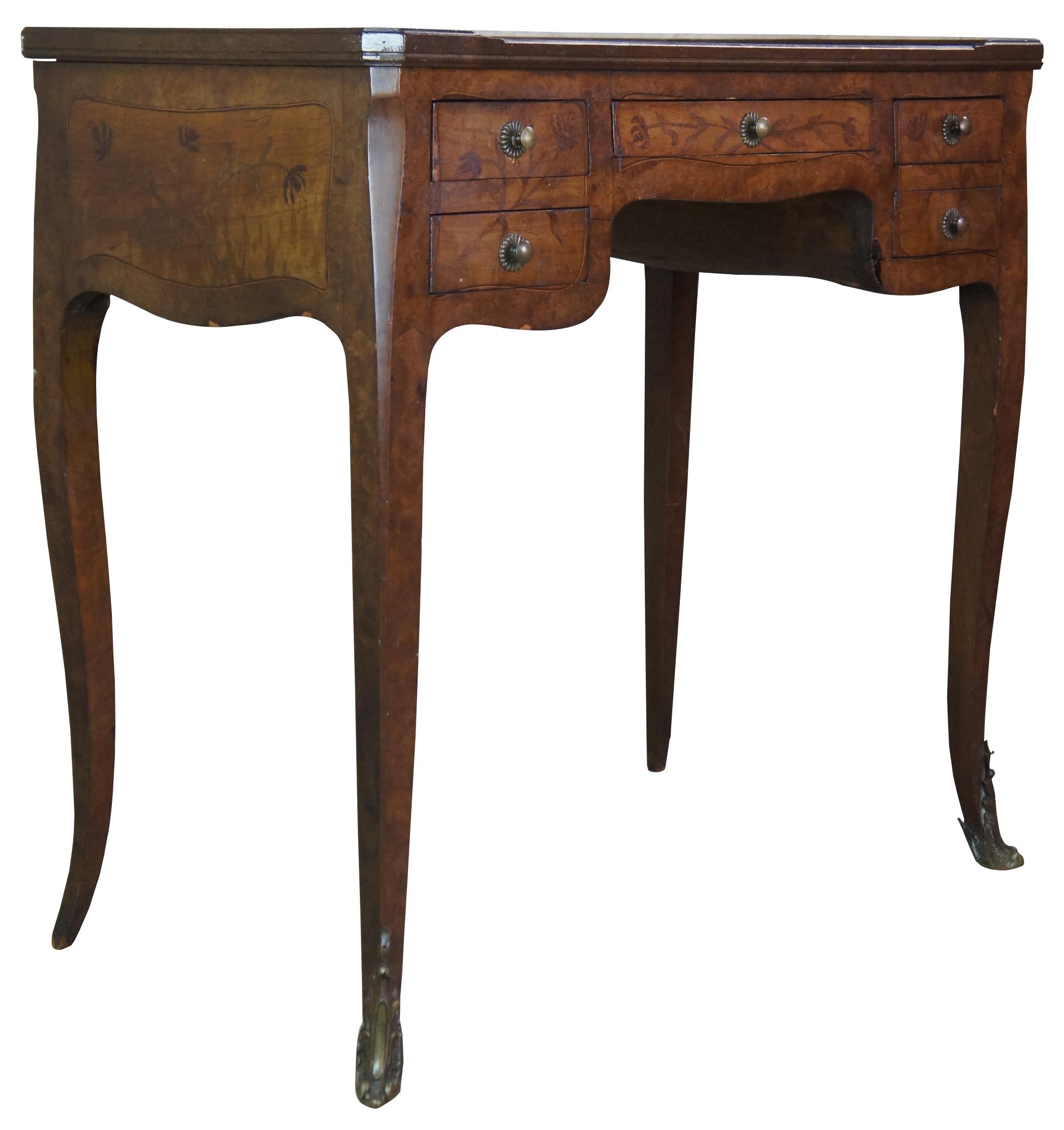 Antique Louis XV / Quinze style petitle ladies writing table, desk or bureau . Made of burl walnut with rectangular form featuring marquetry inlaid floral accents, leather top with gallery, tapered cabriole legs with ormalu feet and finished false