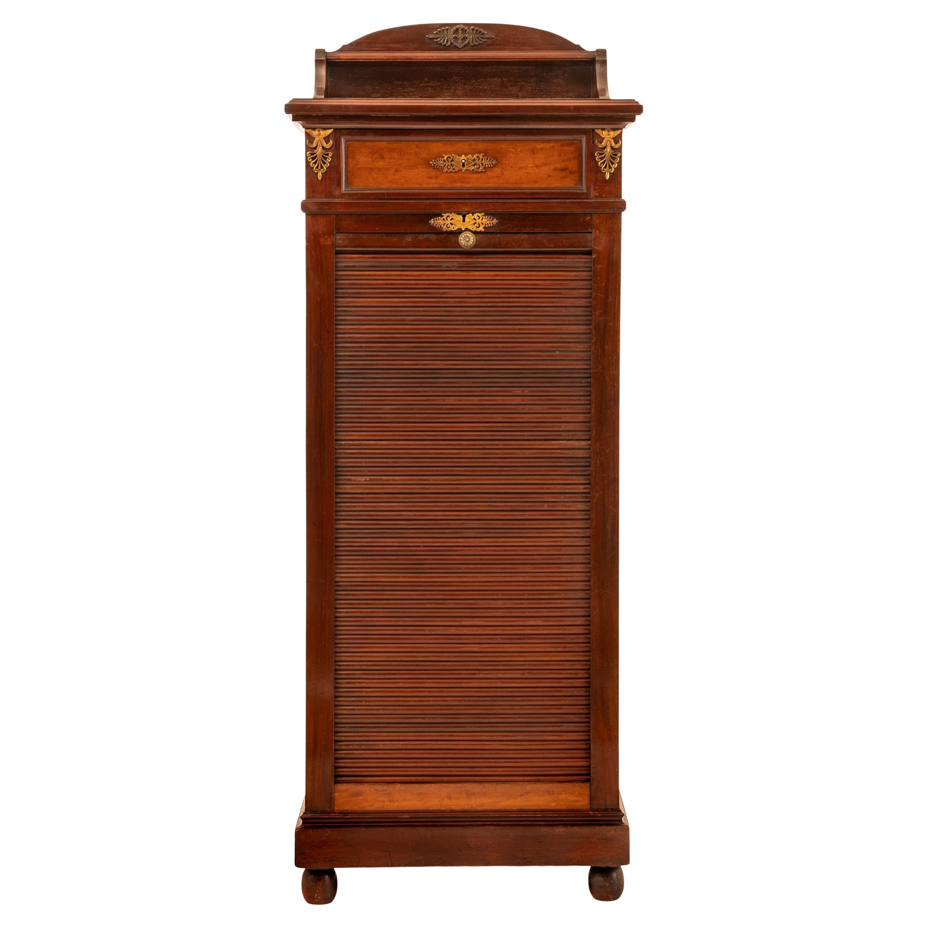 A very good quality antique French Louis XV walnut and ormolu tambour fronted/roll top file cabinet, Paris circa 1900.
The cabinet having a gallery with a single shelf to the rear and an ormolu mount to the top, below is a single locking drawer