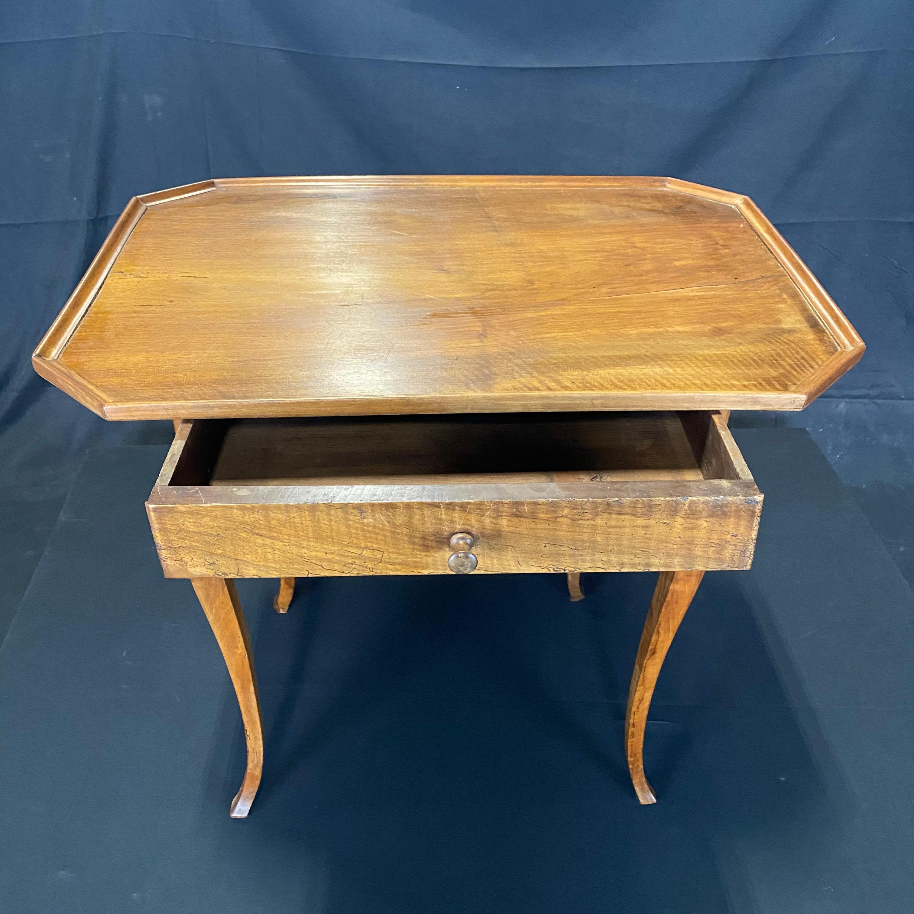 An late 19th century Louis XV style country French walnut side table or nightstand having curved legs and raised gallery. One front drawer is beautifully dovetailed with a small carved knob in the center. Handcrafted of solid walnut using pegged