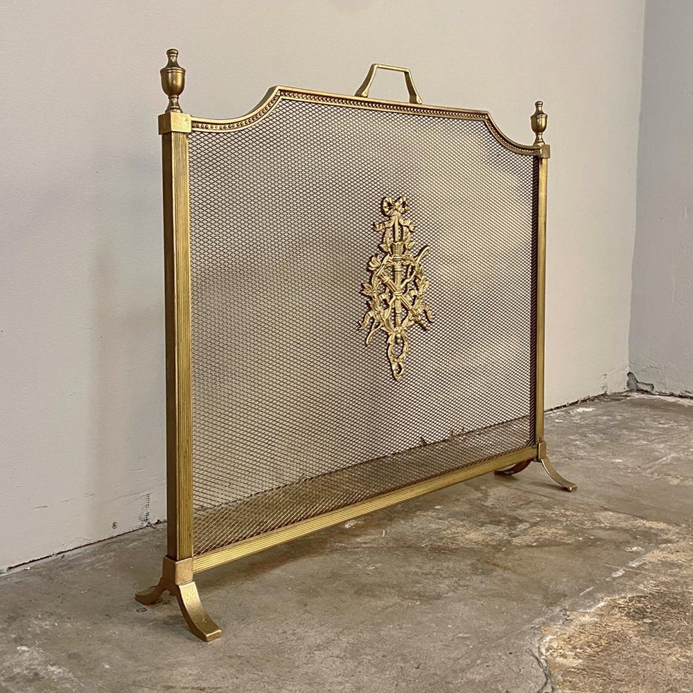 Antique French Louis XVI brass and bronze firescreen was designed to make your fireplace attractive throughout the year! Crafted with a brass framework around fireproof steel mesh, it has been adorned with a cast bronze torchere and carquois de