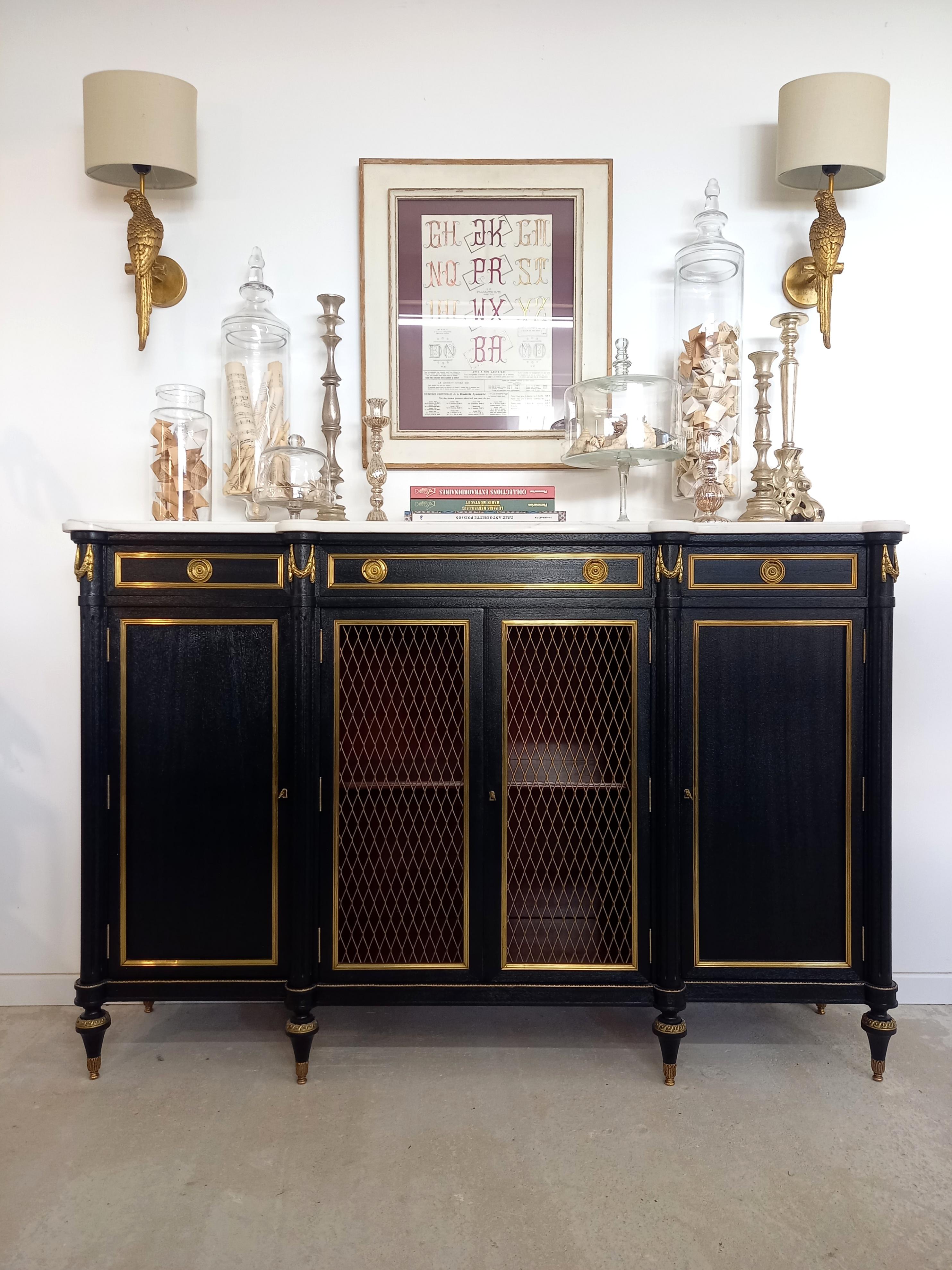 Antique French, Louis XVI style buffet topped with a white marble, fluted legs finished with golden bronze clogs. 
Three dovetailed drawers and four doors with brass details and their keys.
The bronze details all around the piece, are very elegant