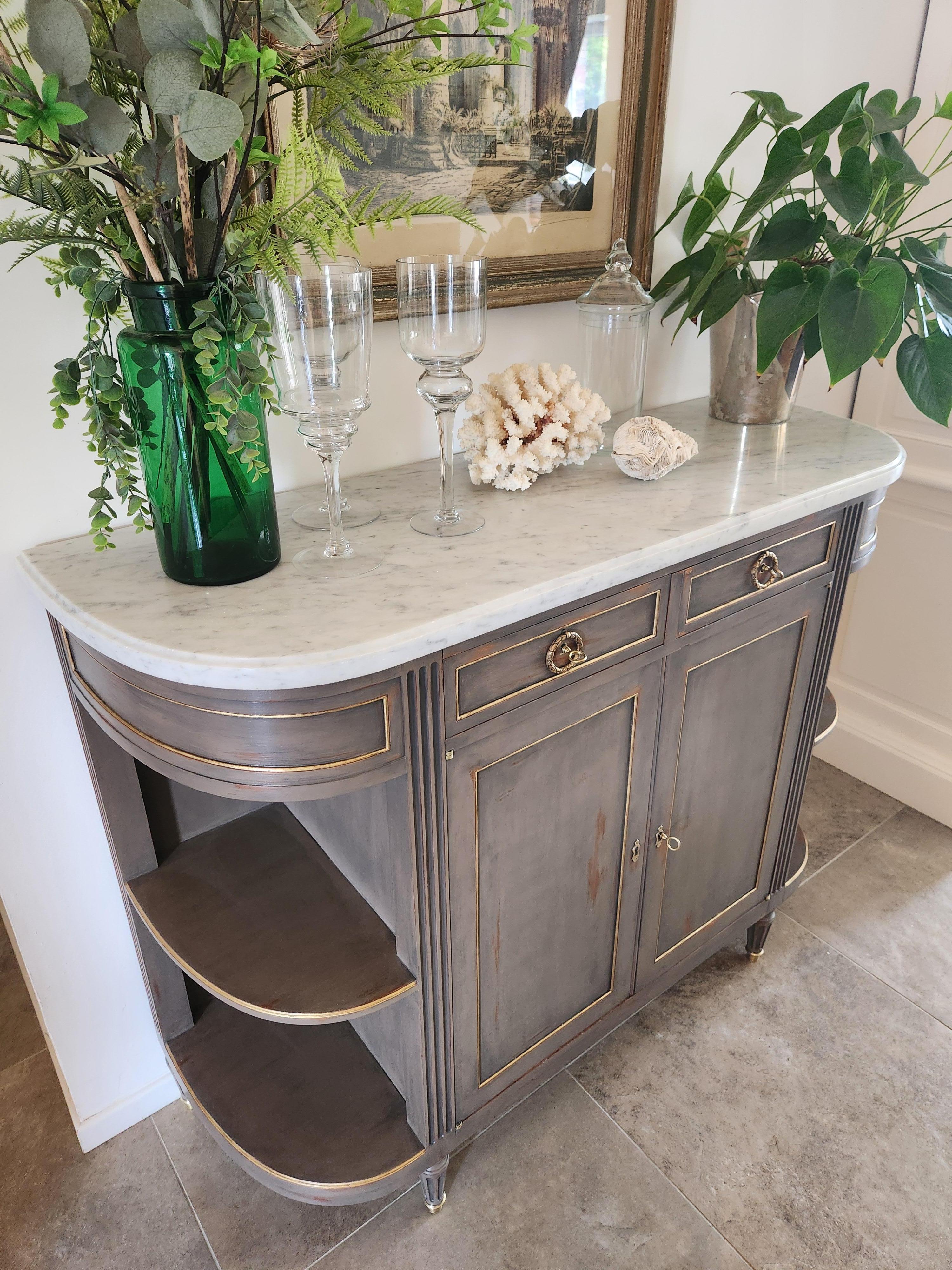 Antique French, buffet in stile Luigi XVI sormontato da un marmo bianco di Carrara, gambe scanalate rifinite con zoccoli in bronzo dorato. 
Due cassetti a coda di rondine e due ante con relative chiavi.
Lo spazio di archiviazione è apprezzabile e
