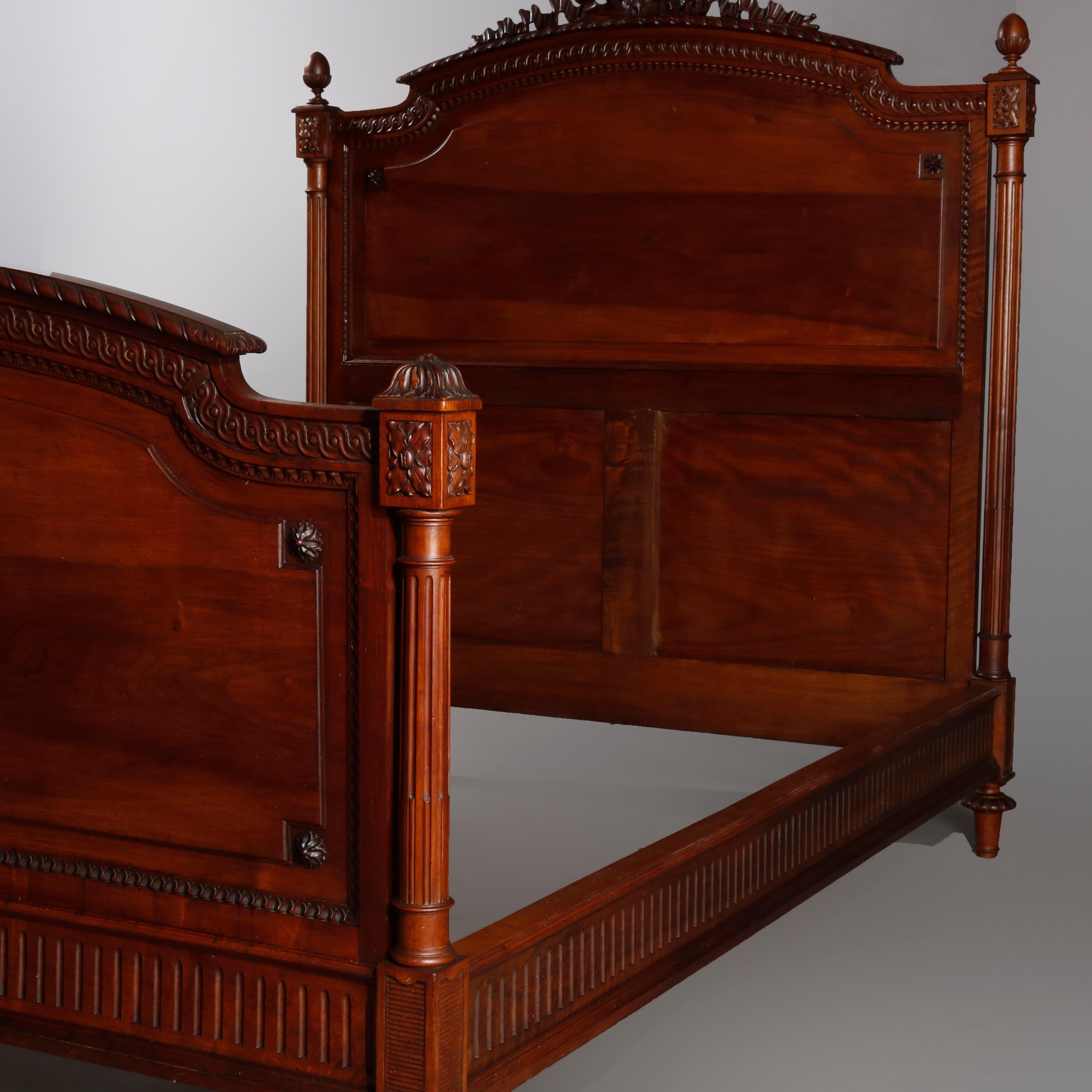 French Louis XVI carved mahogany bed frame with pierced ribbon crest over headboard with heavily carved bordering, rosettes, full turned and reeded columns, acorn finials, raised on turned tapered legs, fluted side rails, 20th century

Measures: